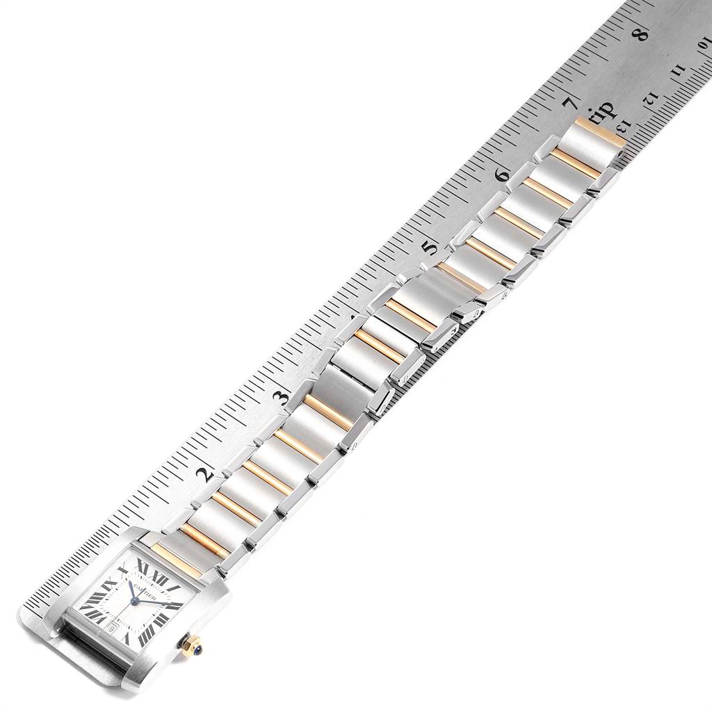 The image shows a Cartier Tank Francaise W51005Q4 Men's Steel and Gold (two tone) Silver Dial W51005Q4 Men's Steel and Gold (two tone) Silver Dial watch, displaying the face and metal band beside a ruler for measurement.