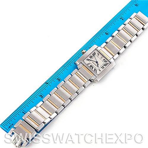 The image shows a top view of the Cartier Tank Française watch and its metal bracelet, placed next to a blue ruler for scale.