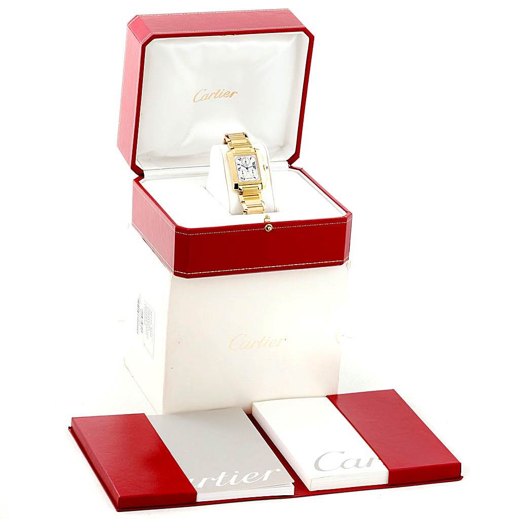 The Cartier Tank Française watch in gold is shown in an open red box with Cartier branding, with additional packaging and booklets.