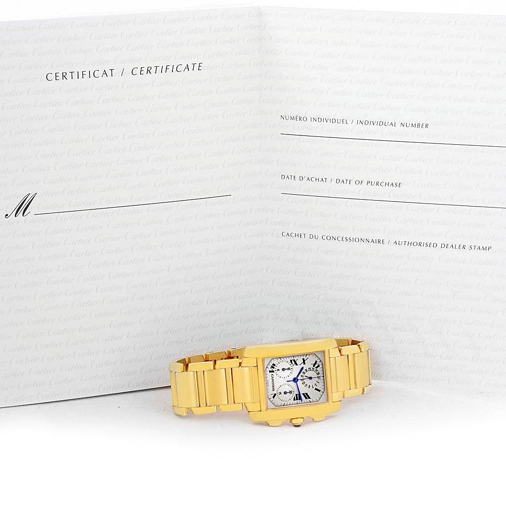 The image shows a Cartier Tank Française watch lying flat with its certificate in the background.