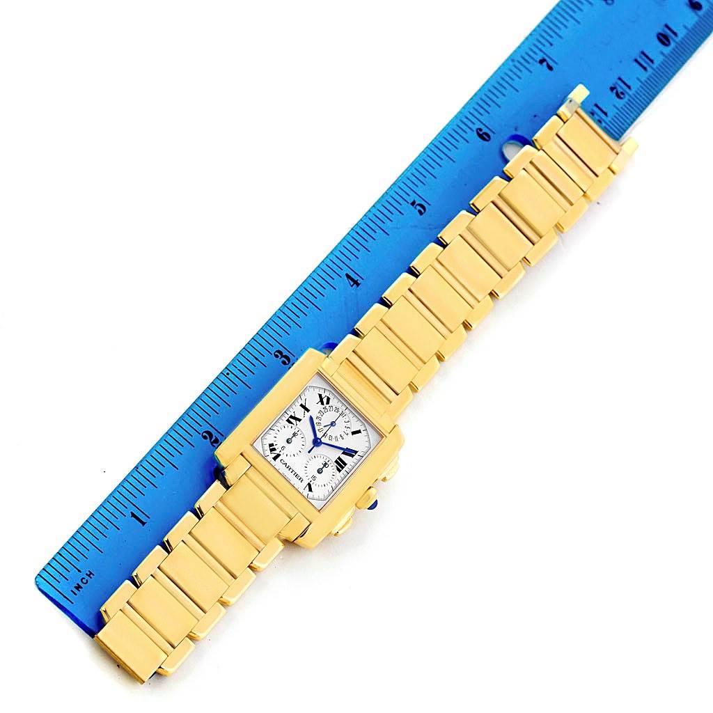 This image shows the Cartier Tank Francaise W50005R2 Men
s Yellow Gold Silver Dial W50005R2 Men
s Yellow Gold Silver Dial watch from a top angle along with a blue ruler for size reference.