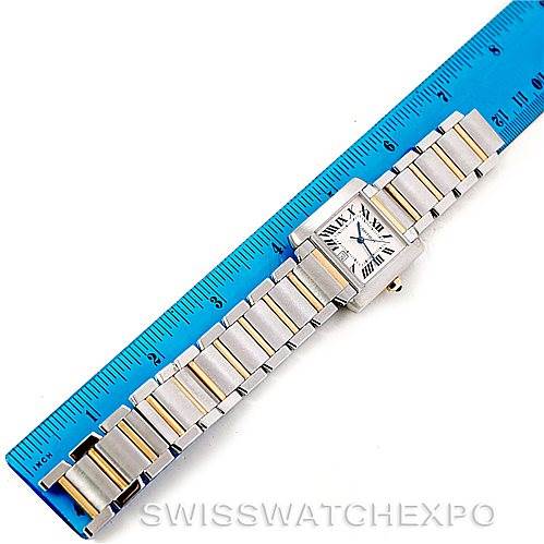 The Cartier Tank Française watch is shown lying flat with its face and bracelet displayed, alongside a blue ruler for scale.