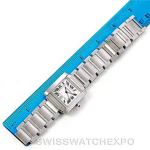 This image shows the Cartier Tank Française watch laid flat next to a blue ruler, displaying the face, bezel, and bracelet.