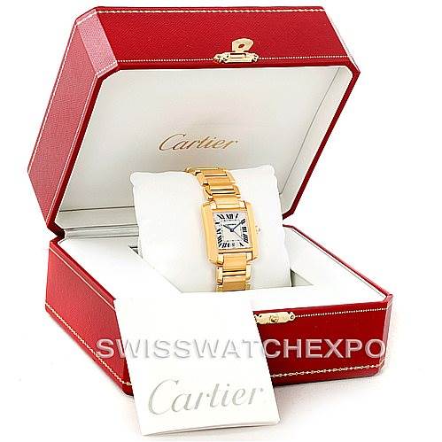 This image shows a Cartier Tank Francaise W50001R2 Men
s Yellow Gold Silver Dial W50001R2 Men
s Yellow Gold Silver Dial watch in a red Cartier box, with a booklet positioned in front.