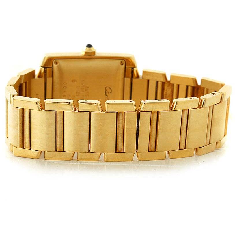 This image shows the back side of the Cartier Tank Francaise W50001R2 Men
s Yellow Gold Silver Dial W50001R2 Men
s Yellow Gold Silver Dial watch with its gold bracelet.