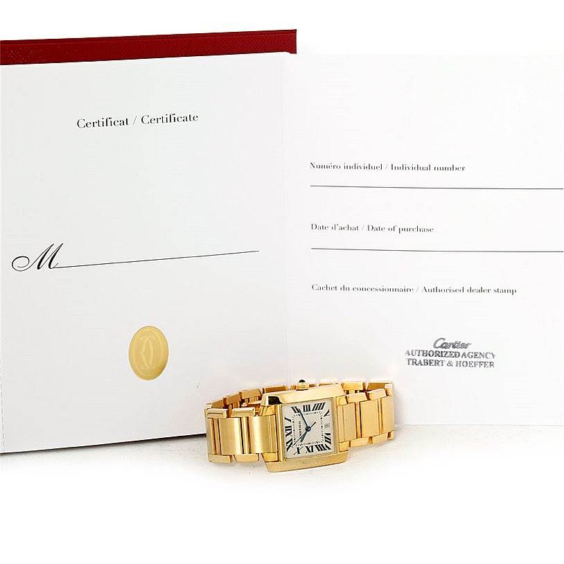 The image shows a Cartier Tank Française watch laid flat, with its certificate and documentation in the background.