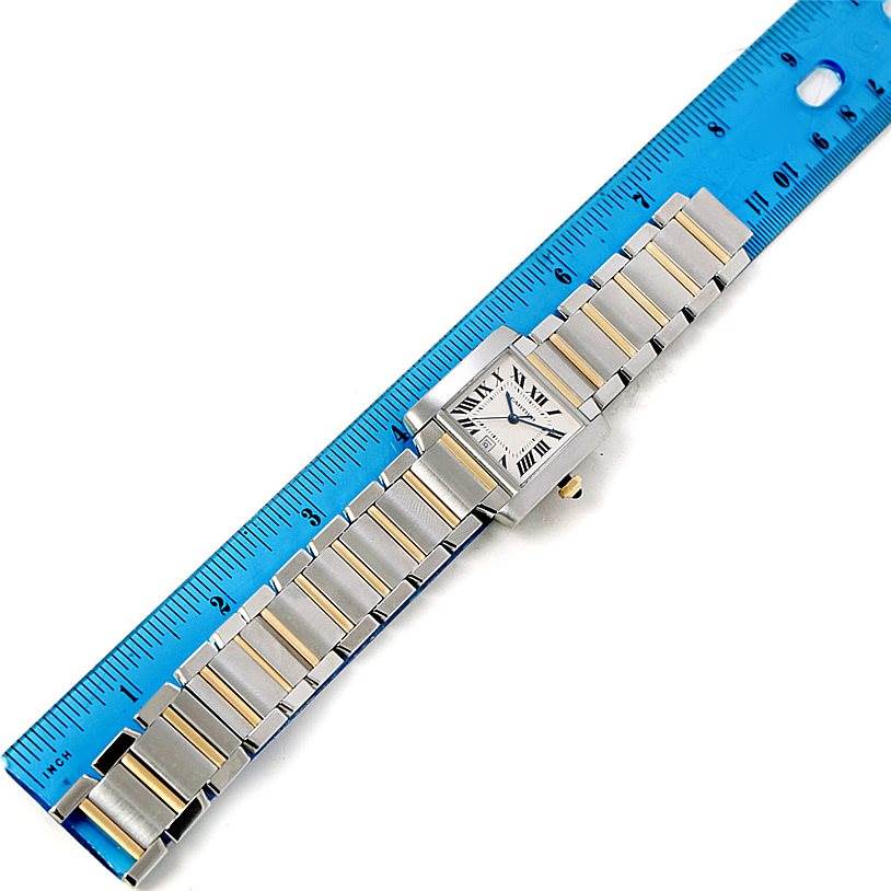 The Cartier Tank Francaise W51005Q4 Men
s Steel and Gold (two tone) Silver Dial W51005Q4 Men
s Steel and Gold (two tone) Silver Dial watch is shown from a top-down angle next to a blue ruler.