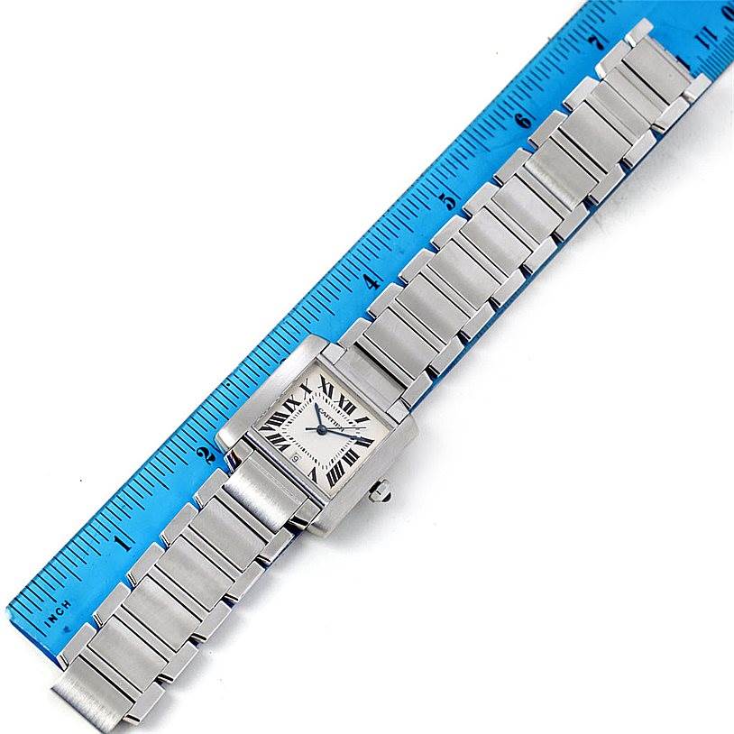 The image shows the Cartier Tank Francaise W51002Q3 Men
s Stainless Steel Silver Dial W51002Q3 Men
s Stainless Steel Silver Dial watch from a top-down angle, along with a blue measuring ruler.