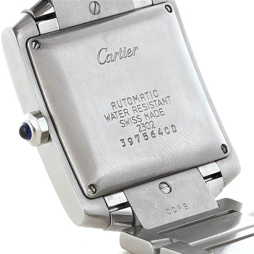 The image shows the back of a Cartier Tank Française watch, highlighting its markings and metal bracelet attachment.