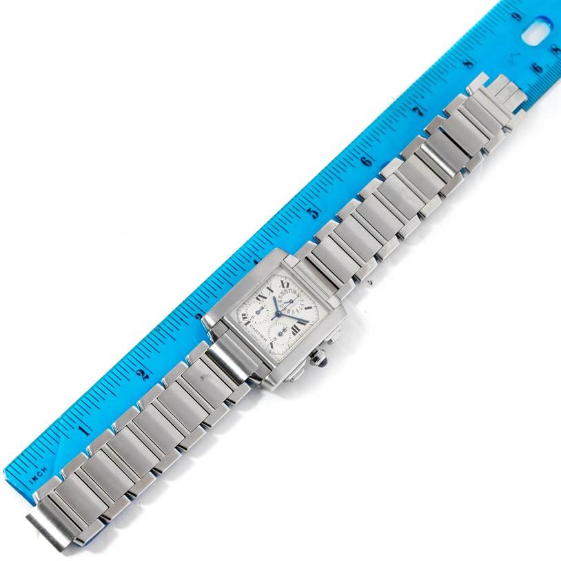 The Cartier Tank Française watch is shown from a top-down angle, with the full bracelet and the face visible against a ruler.