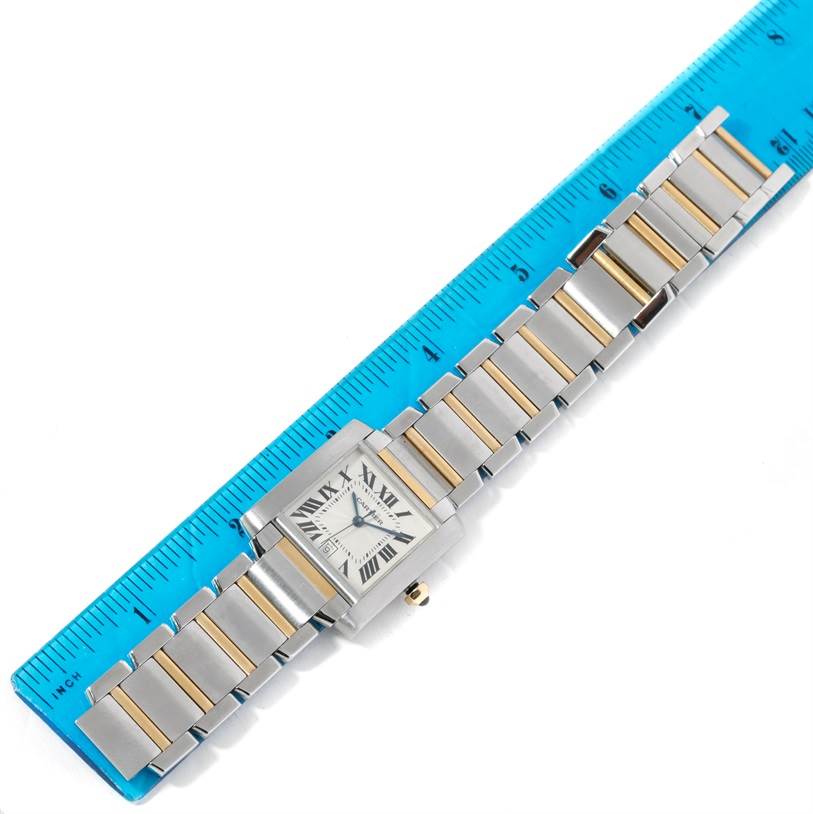 The Cartier Tank Française watch is displayed flat, showing its case, dial, and bracelet along a blue ruler for scale.