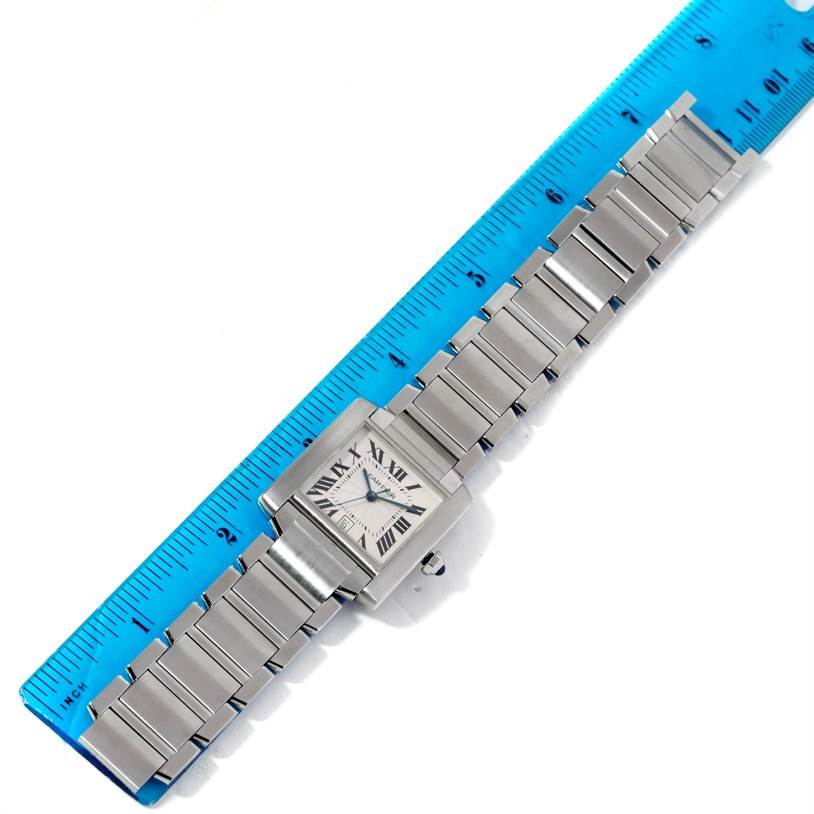 The image shows a Cartier Tank Francaise W51002Q3 Stainless Steel Silver Dial W51002Q3 Stainless Steel Silver Dial watch laid flat next to a ruler, highlighting its bracelet and face from a top-down angle.