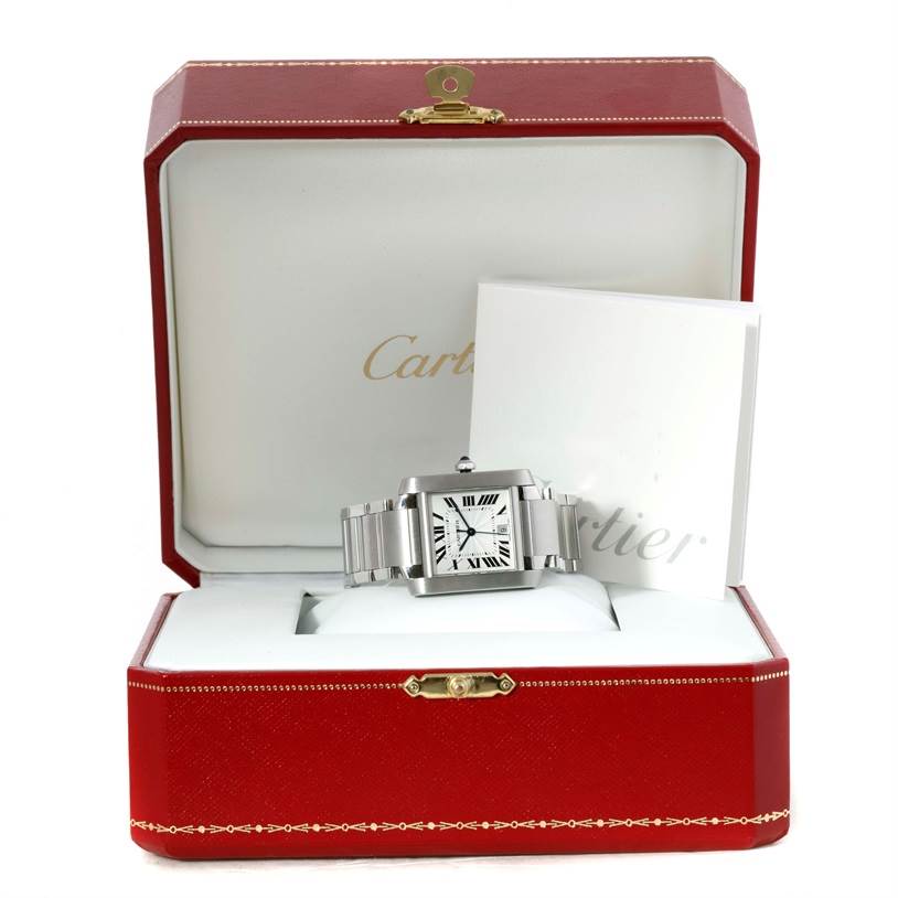 The image shows a Cartier Tank Française watch in its open red box with a booklet beside it.