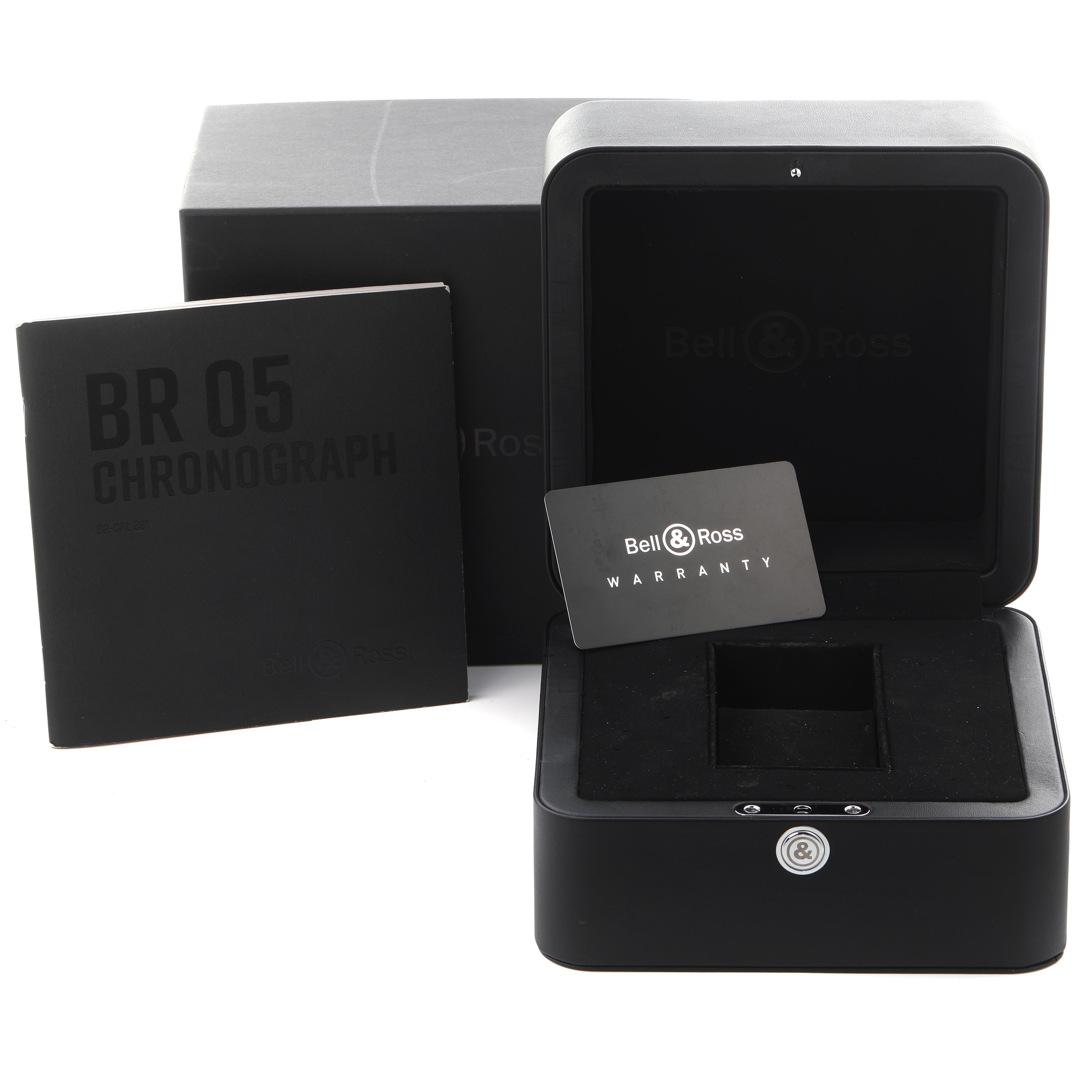 The image shows the Bell 
Ross Urban BR05C-BLC-ST/SST Men
s Stainless Steel Black Dial BR05C-BLC-ST/SST Men
s Stainless Steel Black Dial model watch accessories, including a box, warranty card, and chronograph booklet.