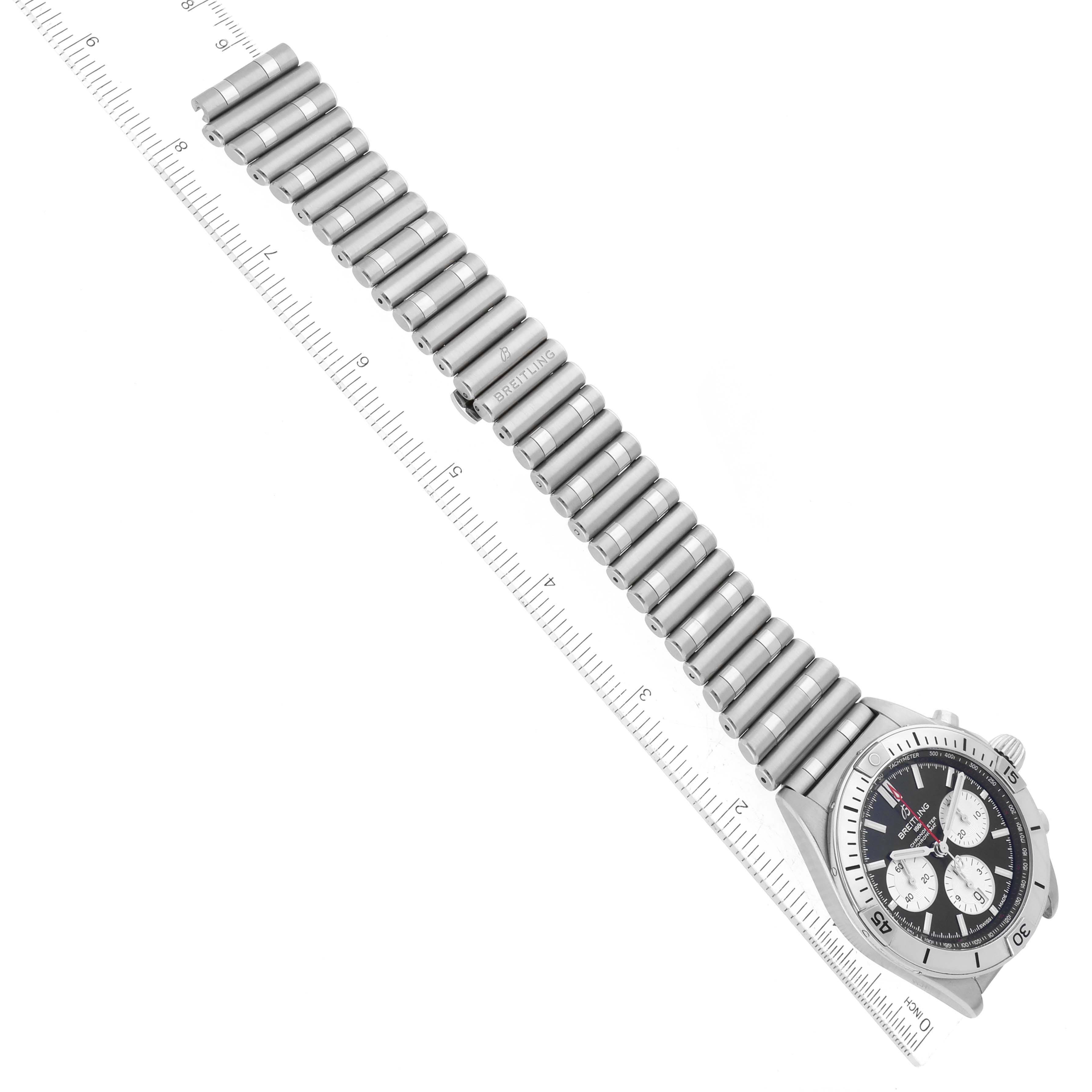 The image shows a Breitling Chronomat AB0134 Men's Stainless Steel Black Dial AB0134 Men's Stainless Steel Black Dial watch laid flat, displaying its face and metal bracelet strap, with a measuring ruler for scale.