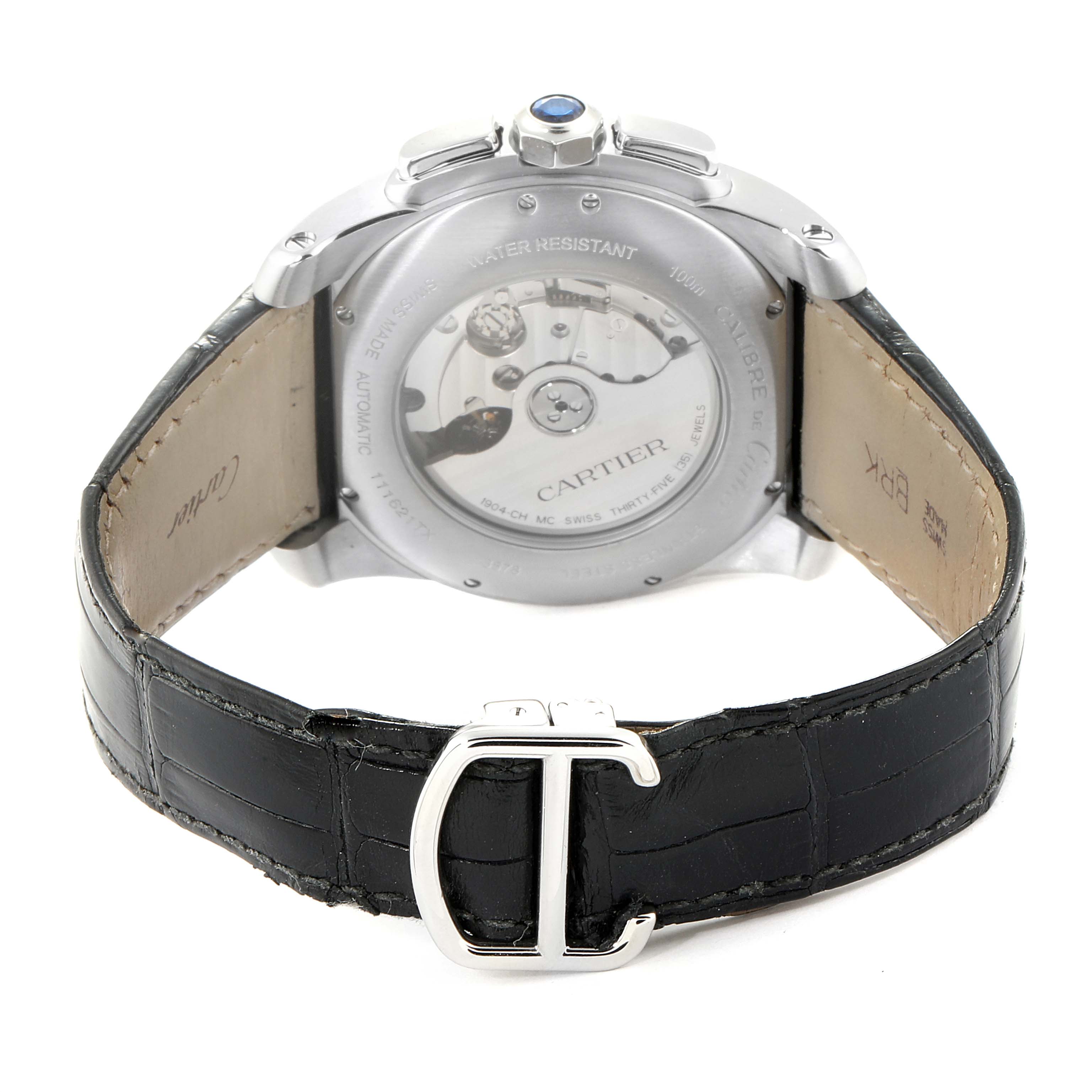 The image shows the back view of the Calibre de Cartier watch by Cartier, displaying its mechanism and leather strap with a buckle.