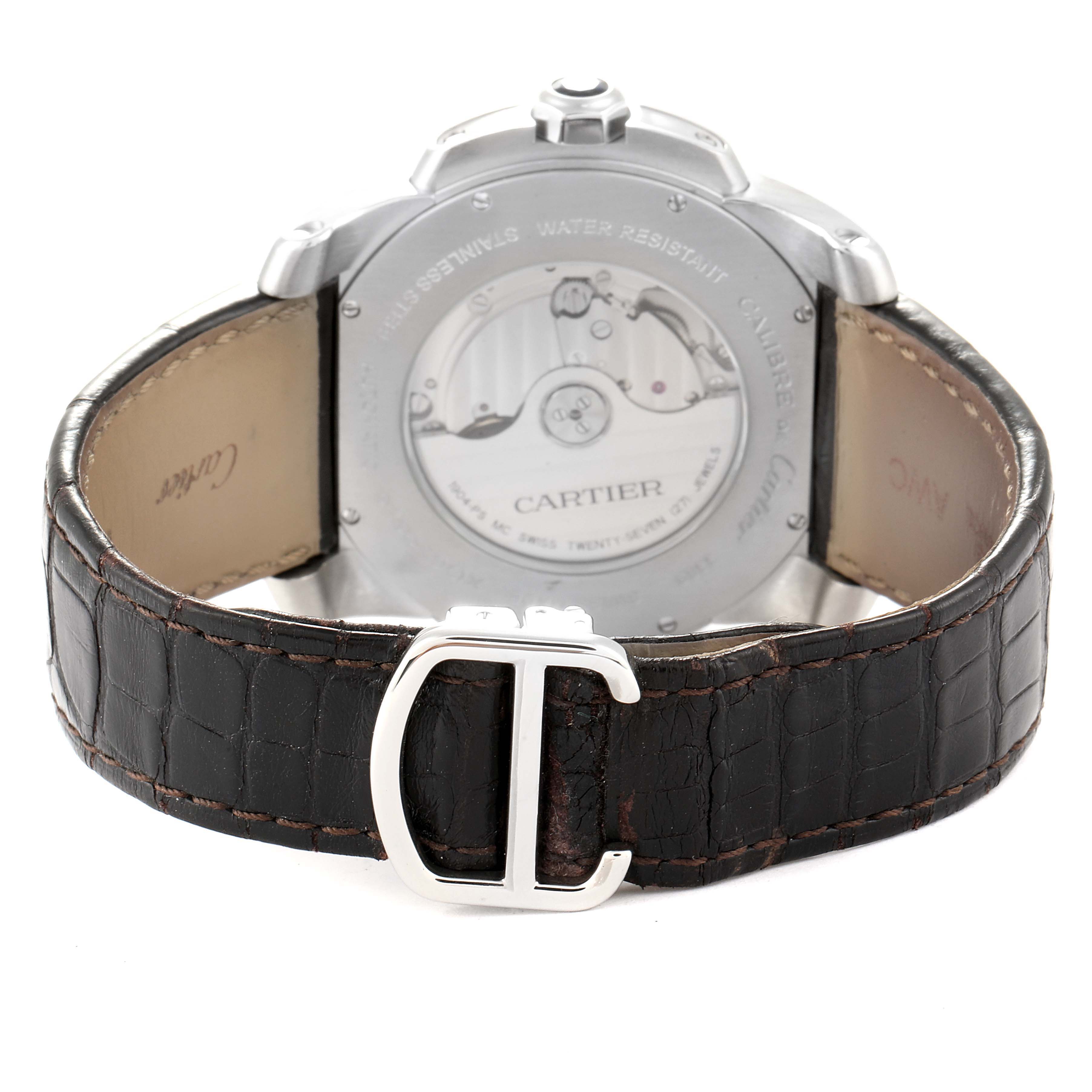 The image shows the back view of a Calibre de Cartier watch by Cartier, highlighting its movement and leather strap with a buckle.
