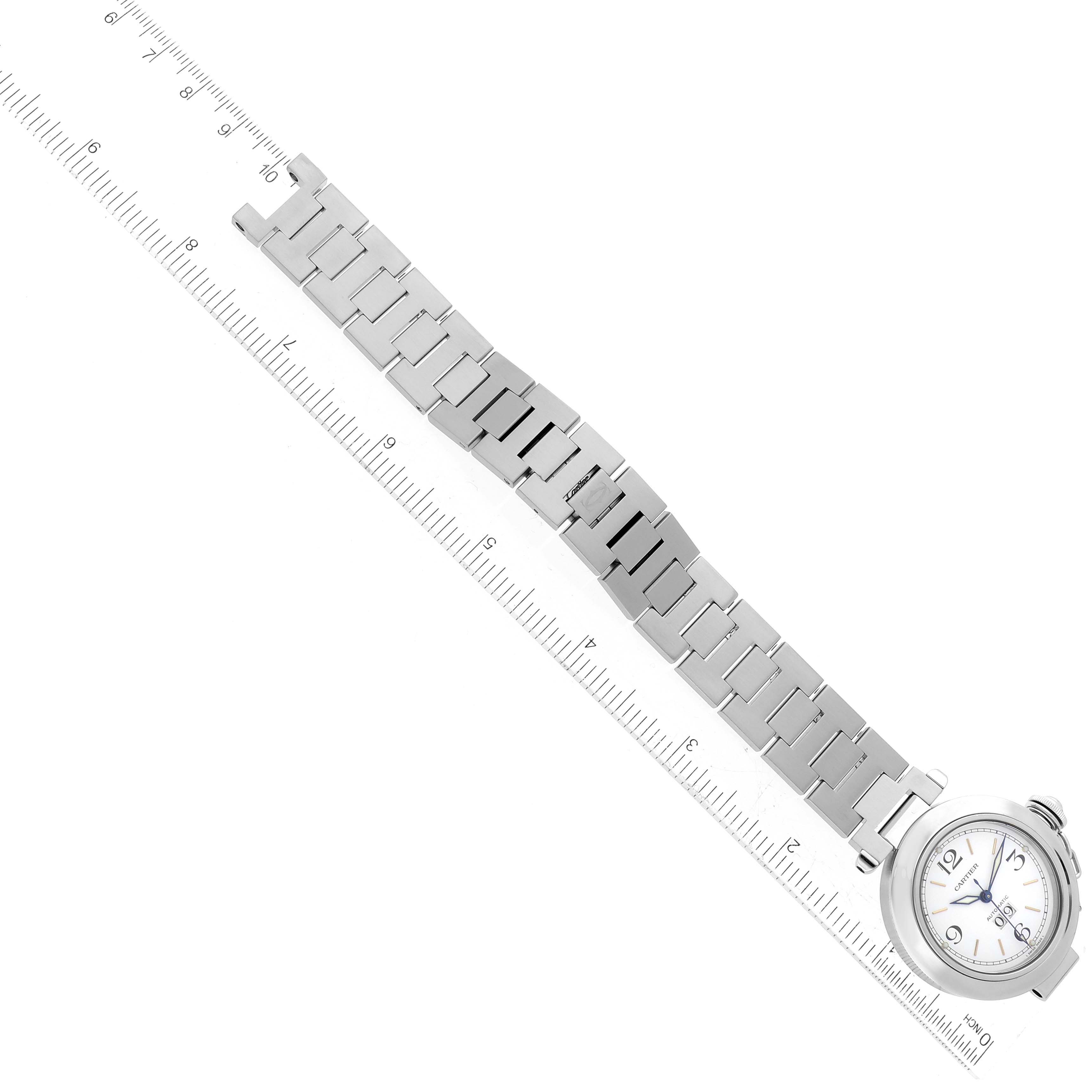 The image shows a Cartier Pasha W31044M7 Men's Stainless Steel White Dial W31044M7 Men's Stainless Steel White Dial watch displayed flat with a ruler, showcasing its full band and face from a top-down angle.