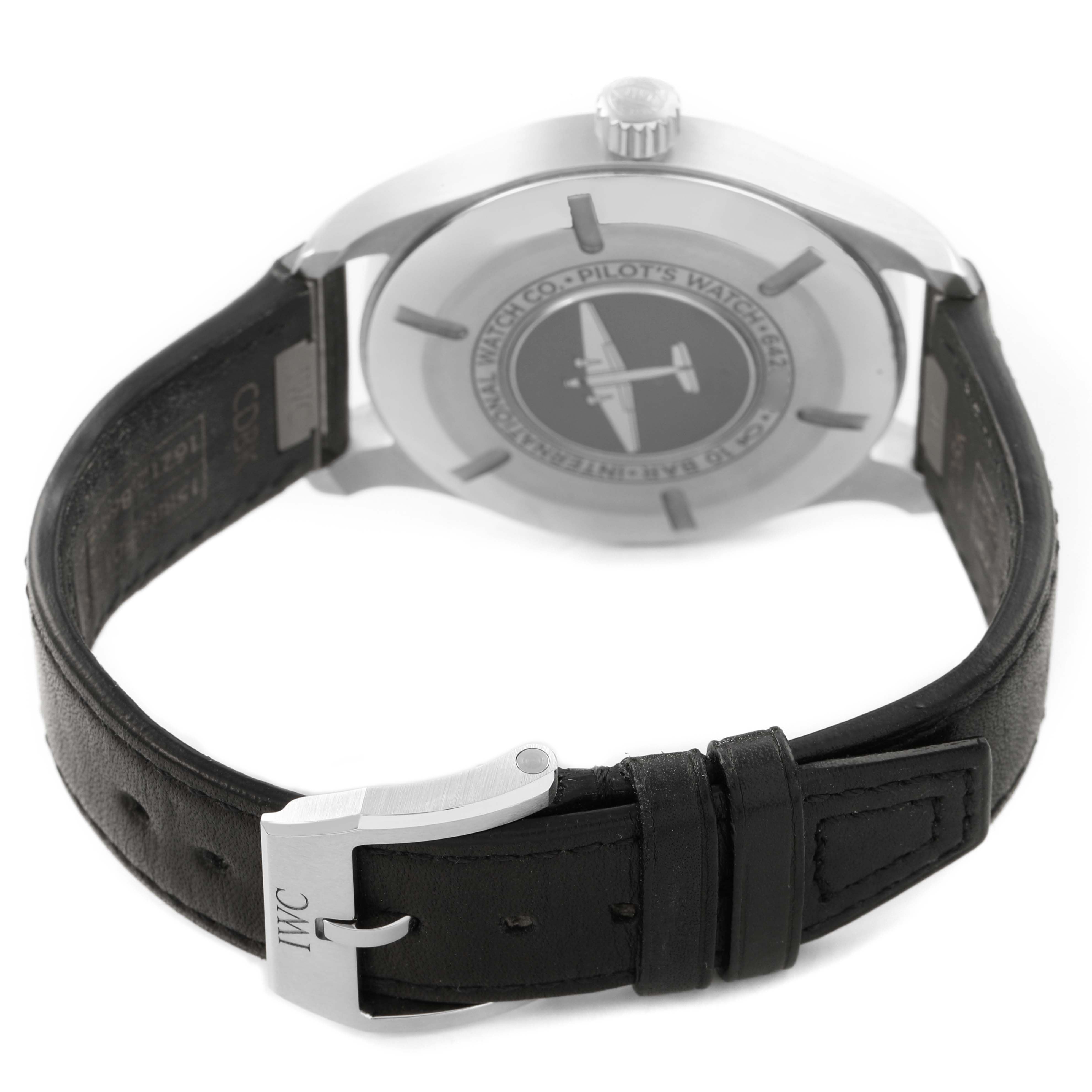 The image shows the back view of an IWC Pilot IW328201 Men's Stainless Steel Black Dial model watch, displaying the case, crown, and leather strap with a buckle clasp.