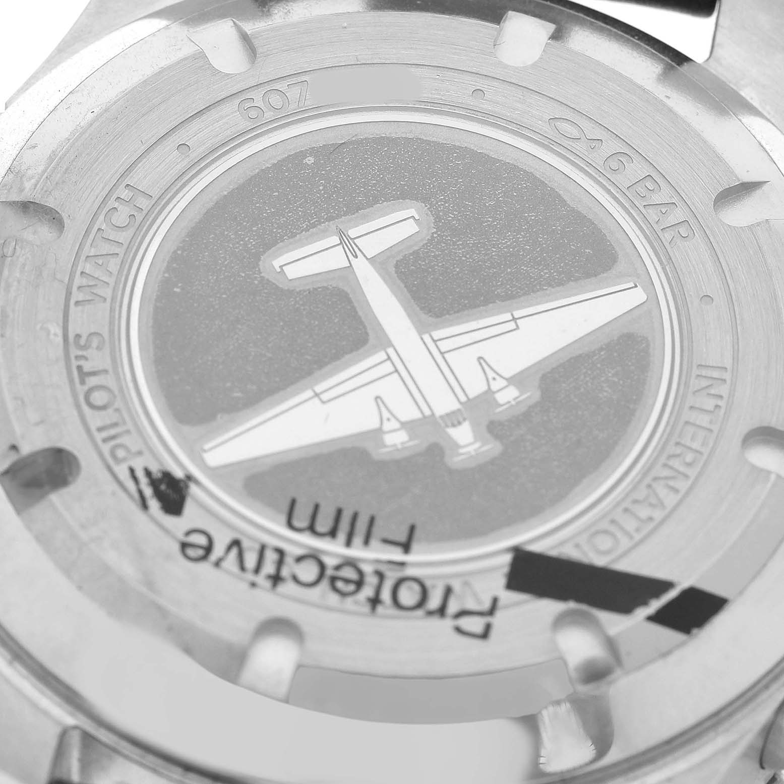 The image shows the back case of an IWC Pilot IW395001 Men's Stainless Steel Black Dial model watch with an engraved airplane design.
