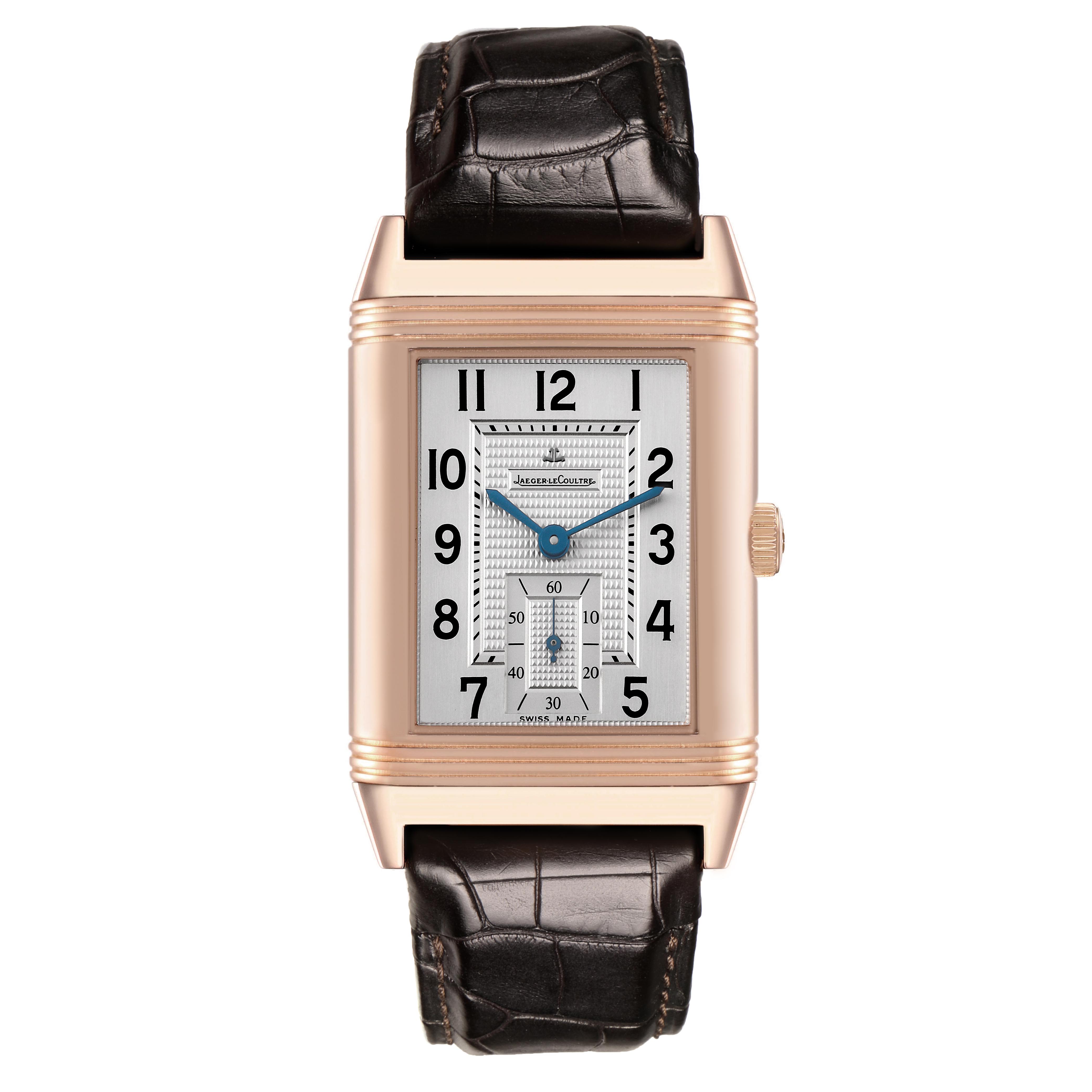 The Jaeger-LeCoultre Reverso watch is shown from the front, displaying its rectangular dial, crown, and leather strap.