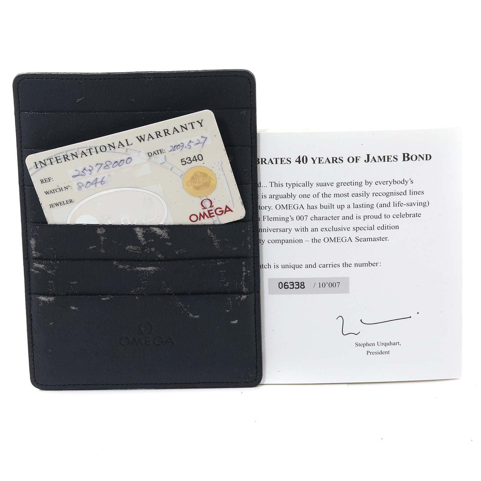 The image shows an Omega Seamaster 2537.80.00 Men's Stainless Steel Blue Dial 2537.80.00 Men's Stainless Steel Blue Dial International Warranty card and a leaflet celebrating 40 years of James Bond, in a black Omega cardholder.