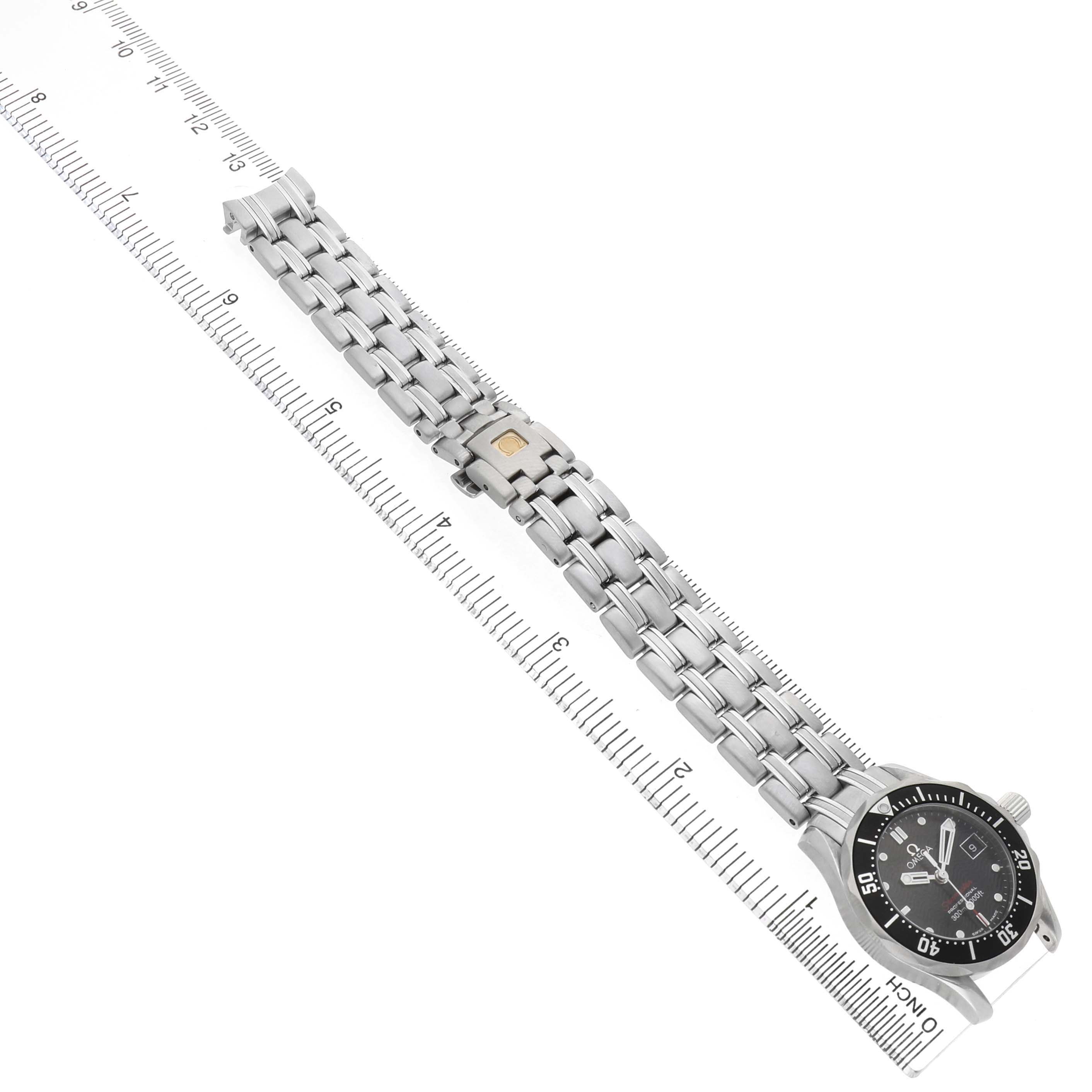 The Omega 212.30.28.61.01.001 Women's Stainless Steel Black Dial Seamaster Diver 300M 28 is shown at a diagonal angle, displaying the full bracelet and face aligned with a ruler.