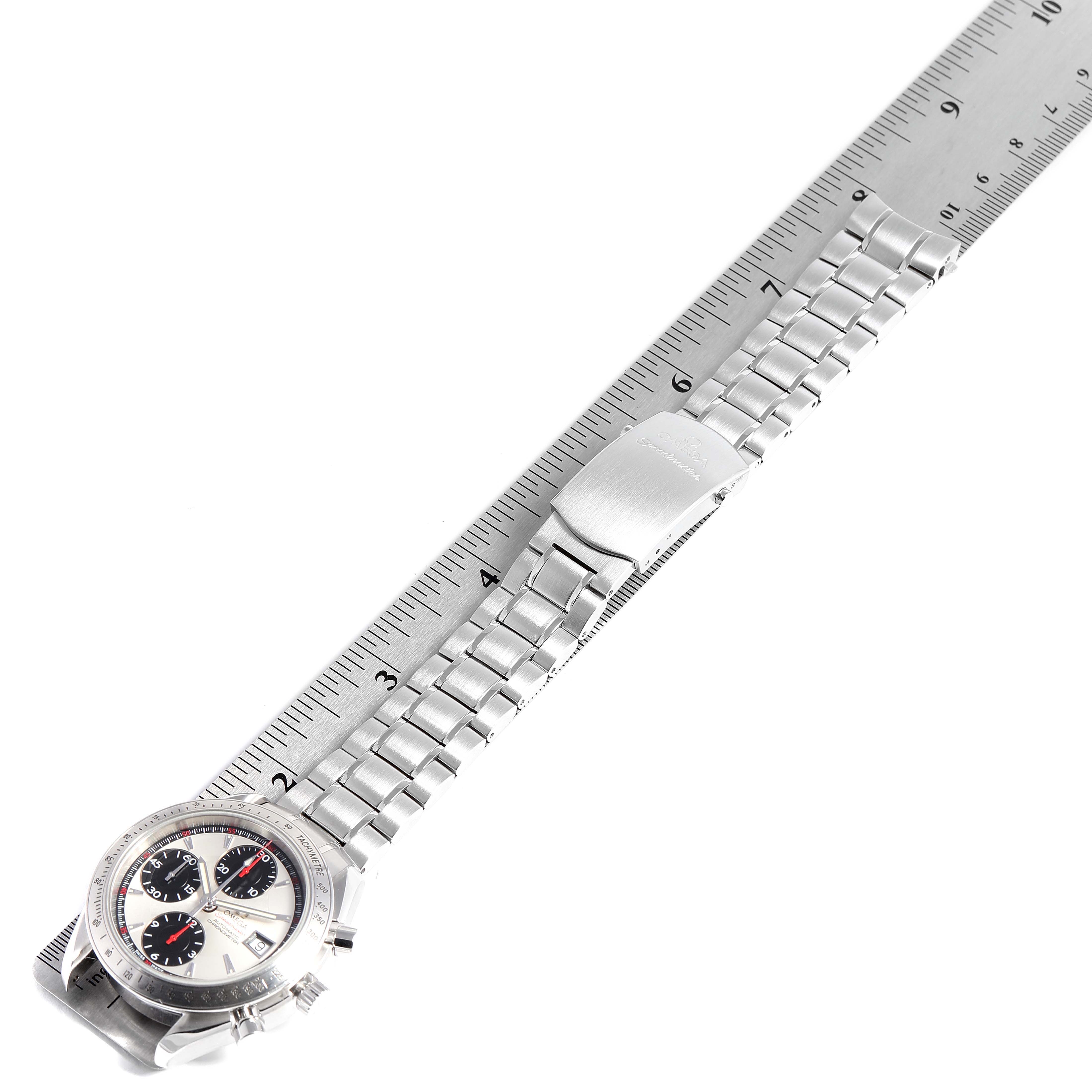 This image shows an Omega Speedmaster 3211.31.00 Men
s Stainless Steel Silver Dial 3211.31.00 Men
s Stainless Steel Silver Dial model watch laying flat with a ruler, displaying the full bracelet and part of the watch face.