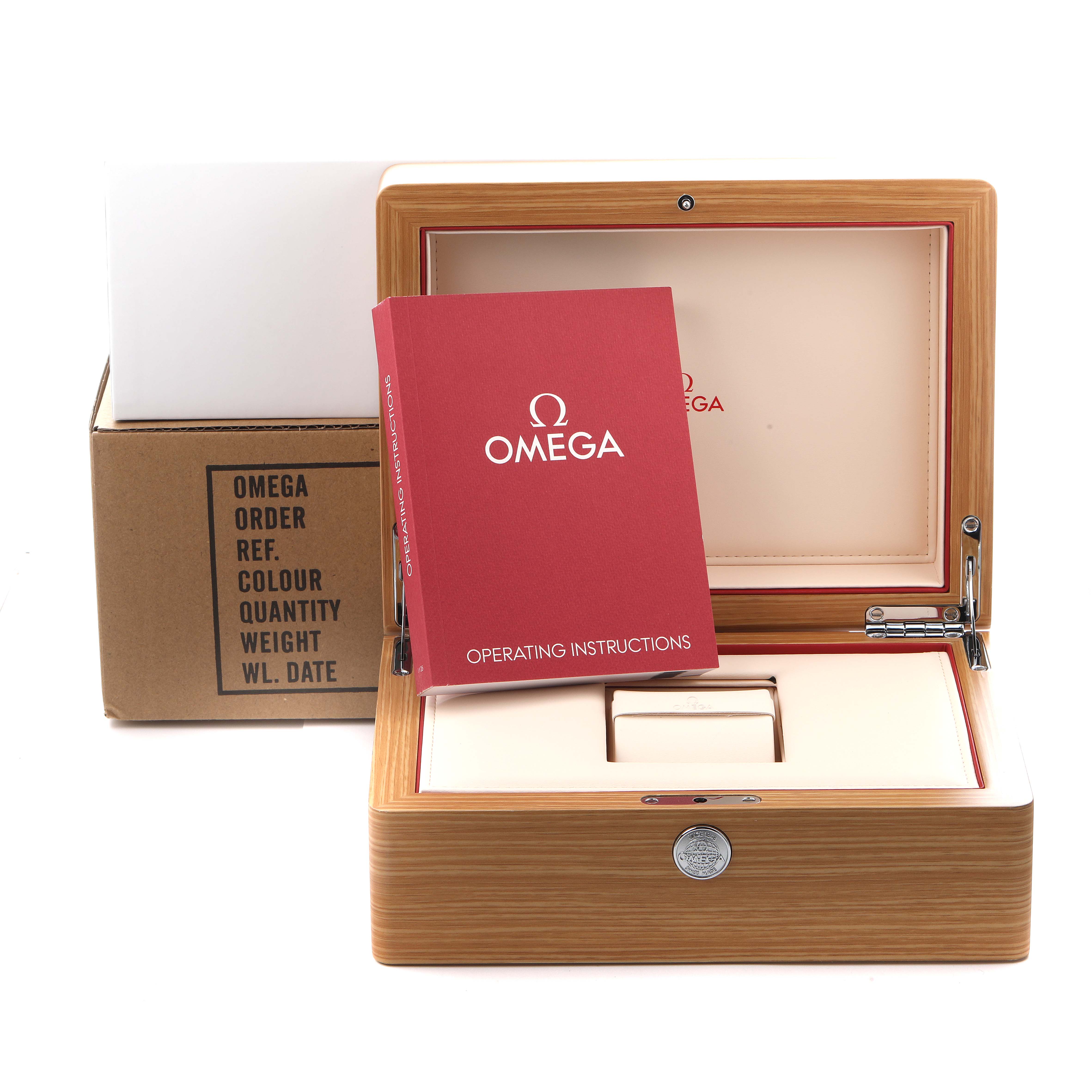 The image shows a wooden Omega Speedmaster 326.32.40.50.11.001 Men's Stainless Steel Red Dial 326.32.40.50.11.001 Men's Stainless Steel Red Dial box with an instruction manual partially covering the box, and a cardboard sleeve in the background.