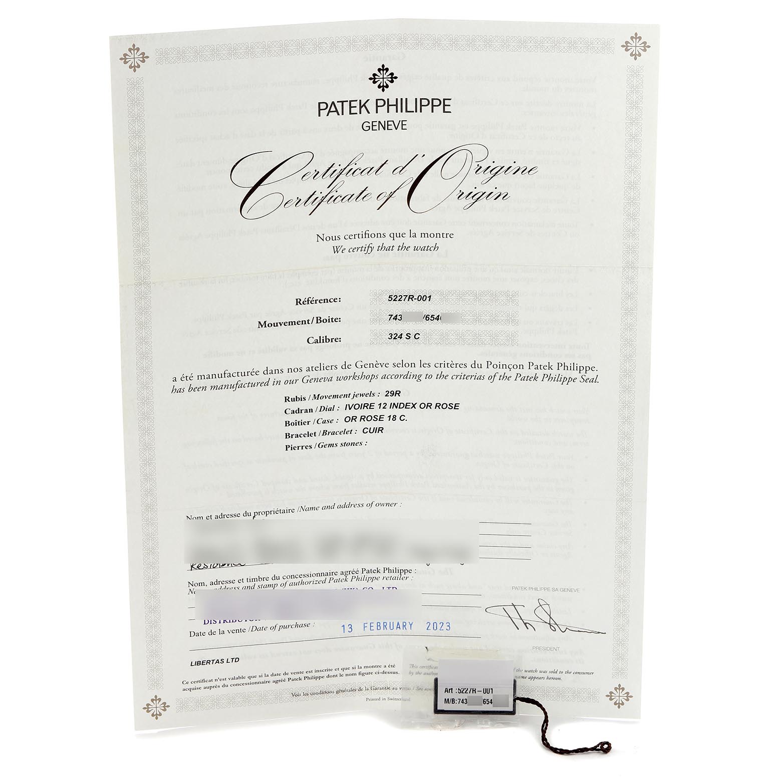 The image shows a certificate of origin and a tag for the Patek Philippe Calatrava 5227R-001 Men's Rose Gold White Dial 5227R-001 Men's Rose Gold White Dial watch, viewed frontally.