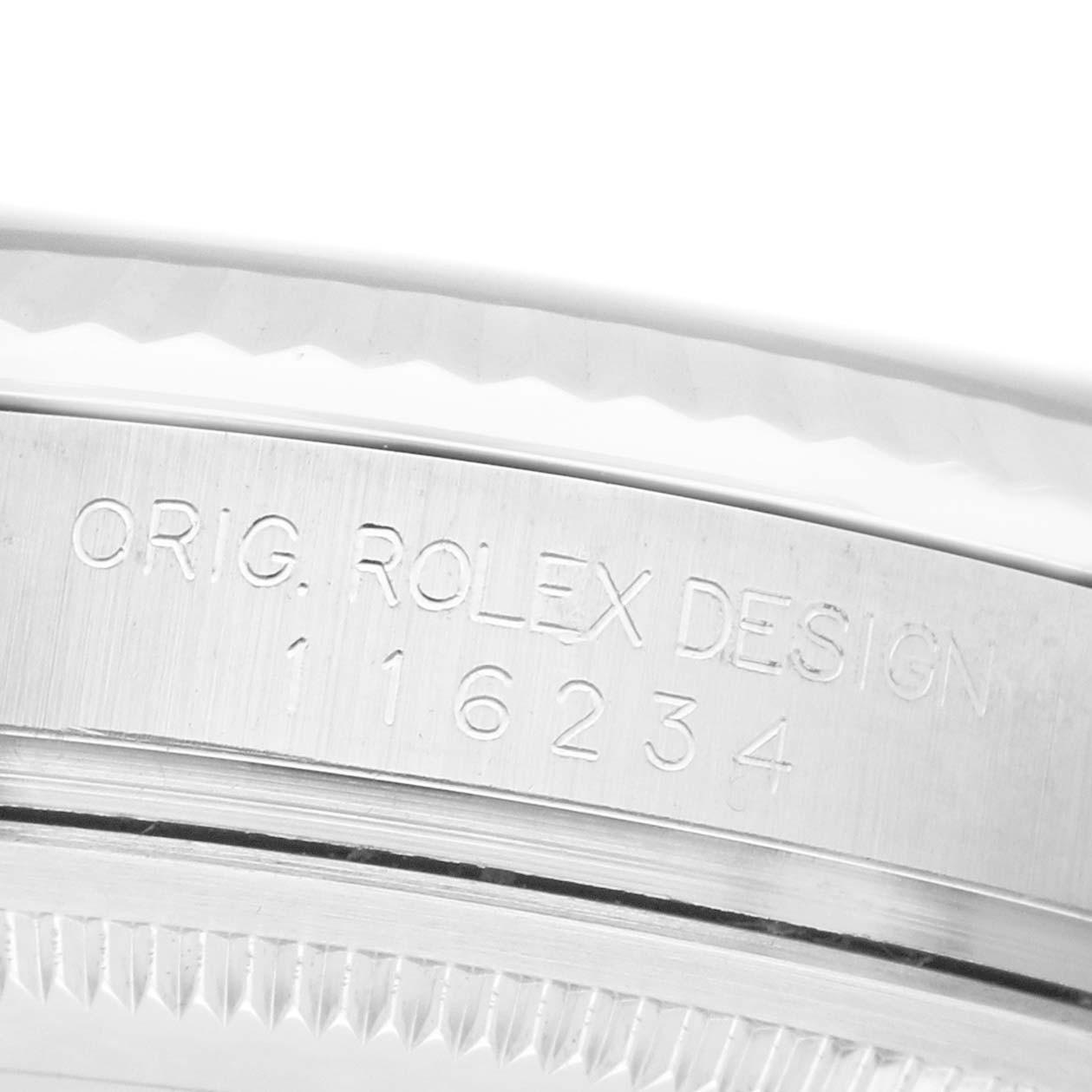 The image shows a close-up of the engraved side of a Rolex Datejust 116234 Men's Stainless Steel Blue Dial watch case, displaying design and model number details.