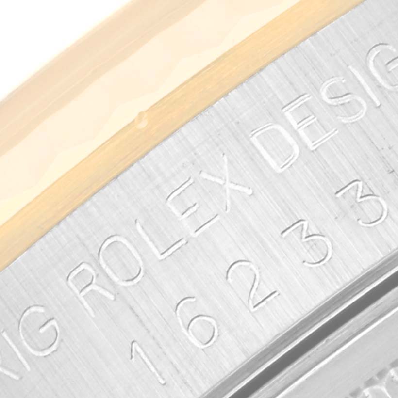 Close-up view of the side of the bezel of a Rolex Datejust 16233 Men's Steel and Gold (two tone) Champagne Dial 16233 Men's Steel and Gold (two tone) Champagne Dial, clearly showing engraved model numbers and brand details.