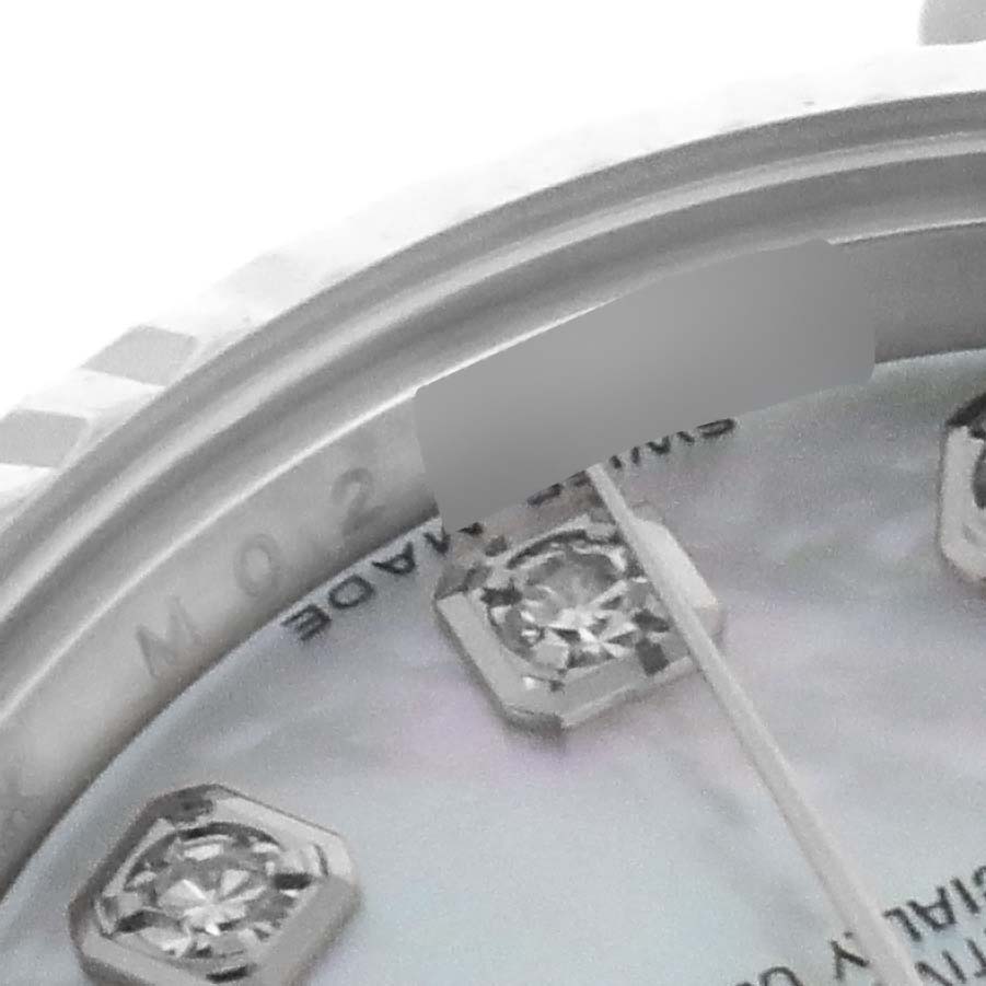 This close-up image of the Rolex Datejust 179174 Women's Stainless Steel Mother of Pearl Dial 179174 Women's Stainless Steel Mother of Pearl Dial model shows part of the dial with diamond markers and a portion of the fluted bezel.