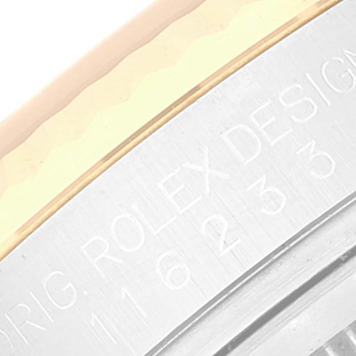 The image shows a close-up of the engraved side of the Datejust model by Rolex, highlighting the serial number and part of the bezel.