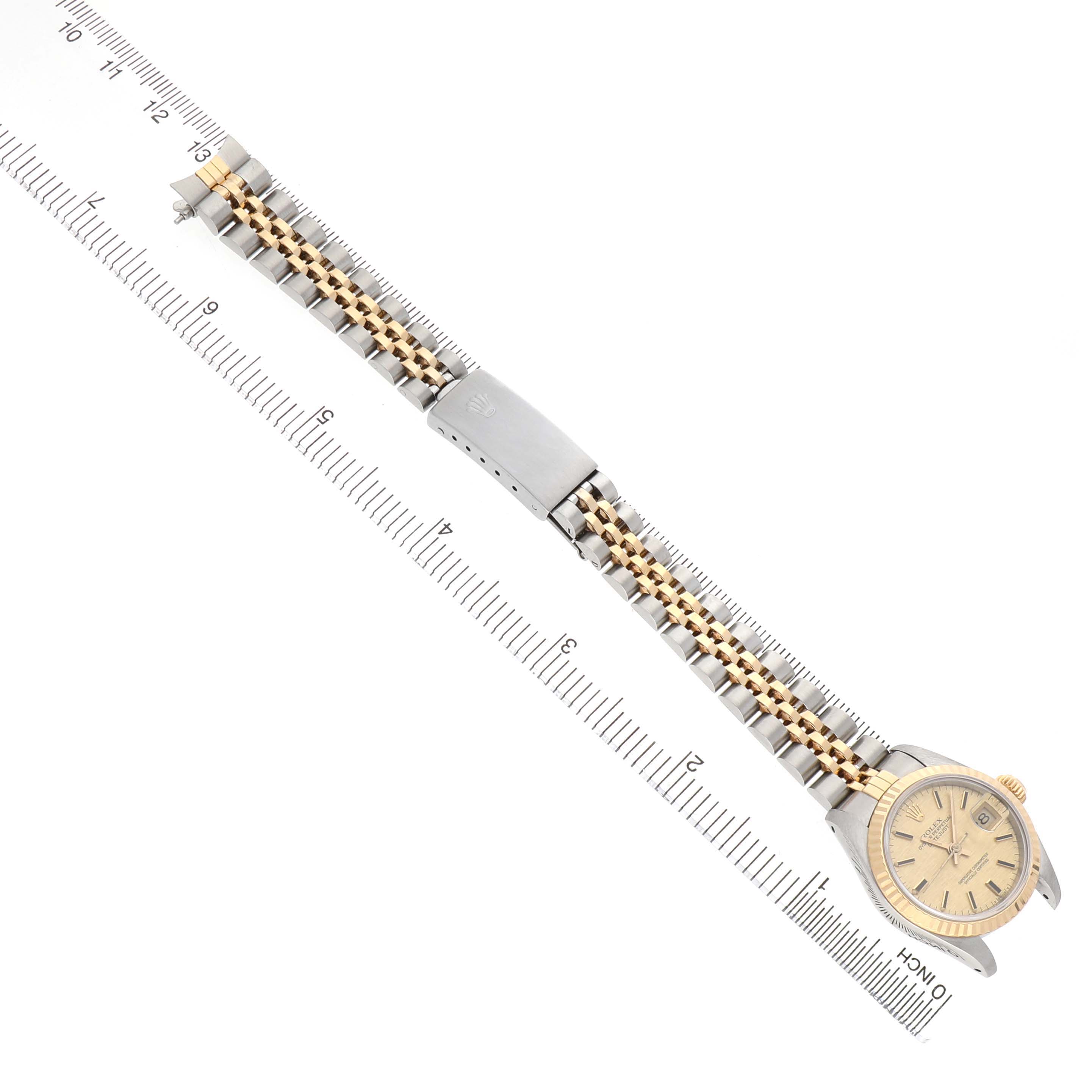 The Rolex Datejust 69173 Women's Steel and Gold (two tone) Champagne Dial watch is shown from a top-down angle, displaying its dial, case, and full bracelet.