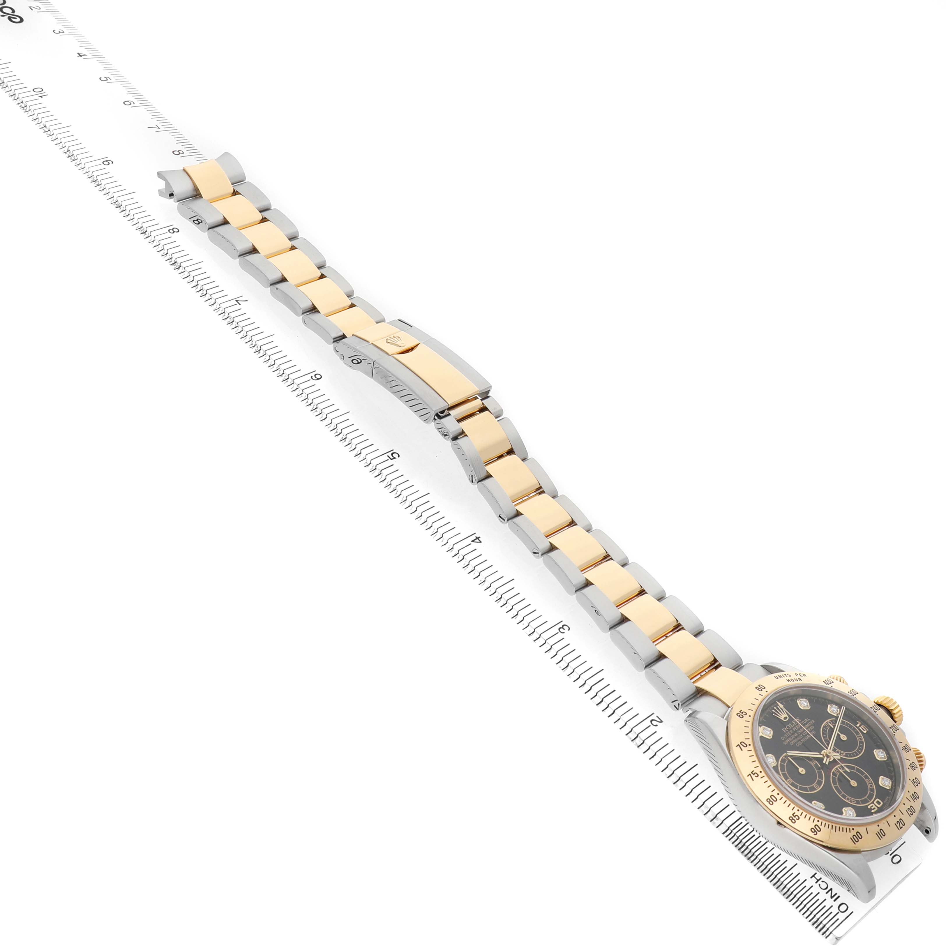 The image shows a Rolex Daytona 116523 Men's Steel and Gold (two tone) Black Dial watch viewed diagonally, highlighting its bracelet, clasp, and part of the face.