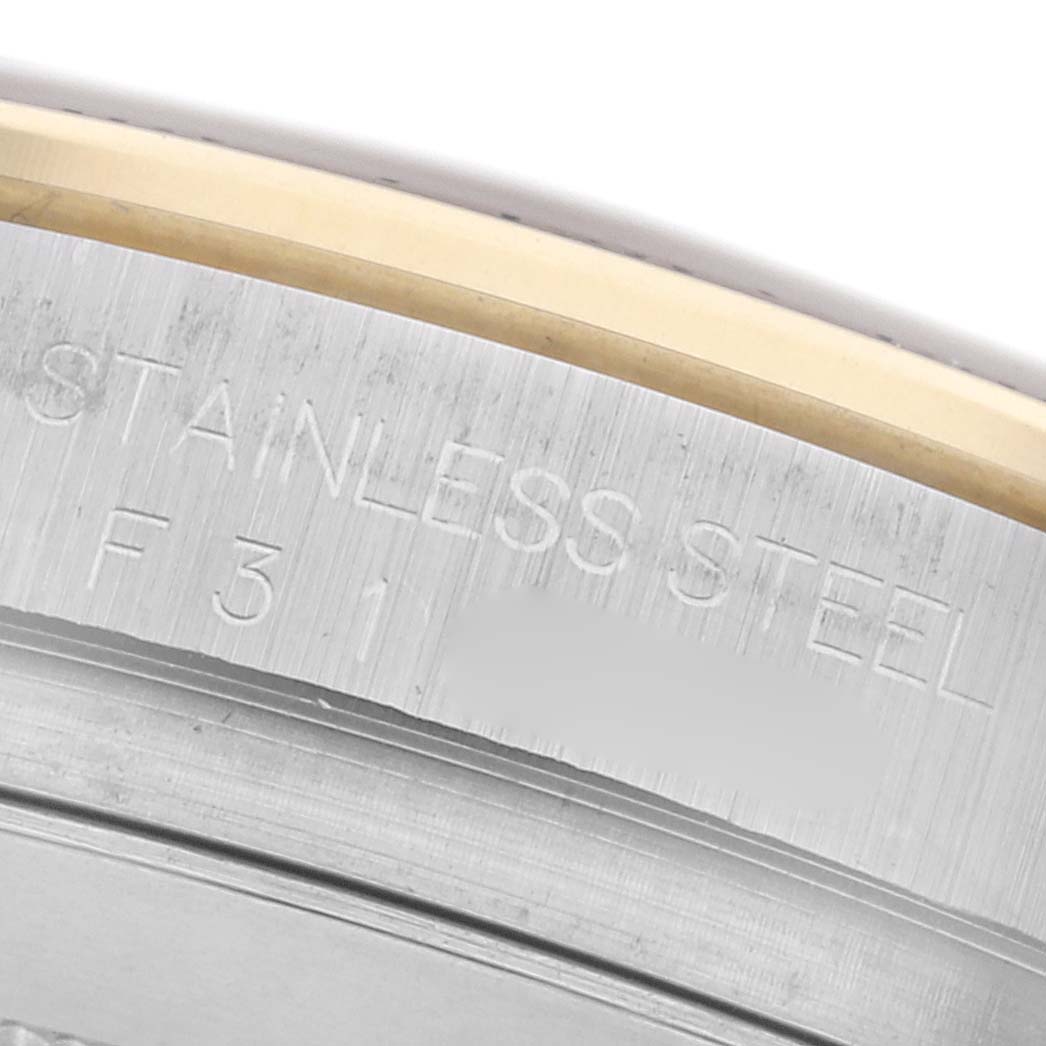 The image shows a close-up of the side bezel of a Rolex Daytona 116523 Men's Steel and Gold (two tone) White Dial 116523 Men's Steel and Gold (two tone) White Dial, highlighting "Stainless Steel" engraving.