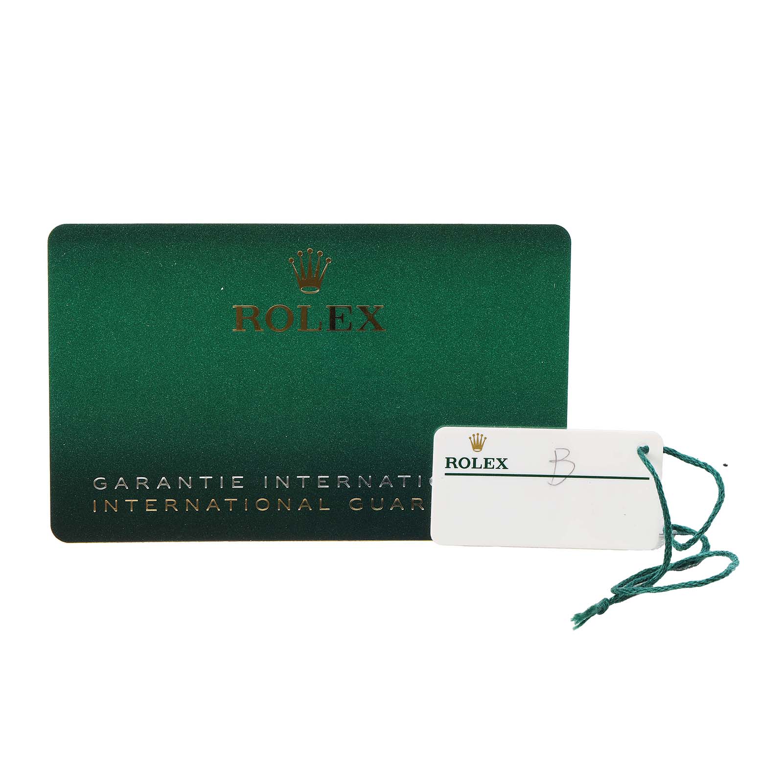 The image shows a green Rolex Garantie Internationale card and a Rolex tag with a string, related to the Explorer model.