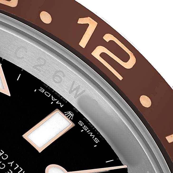 The image shows a close-up of the Rolex GMT-Master 126711CHNR Men's Steel and Gold (two tone) Black Dial watch, highlighting part of the bezel, dial, and hour marker.