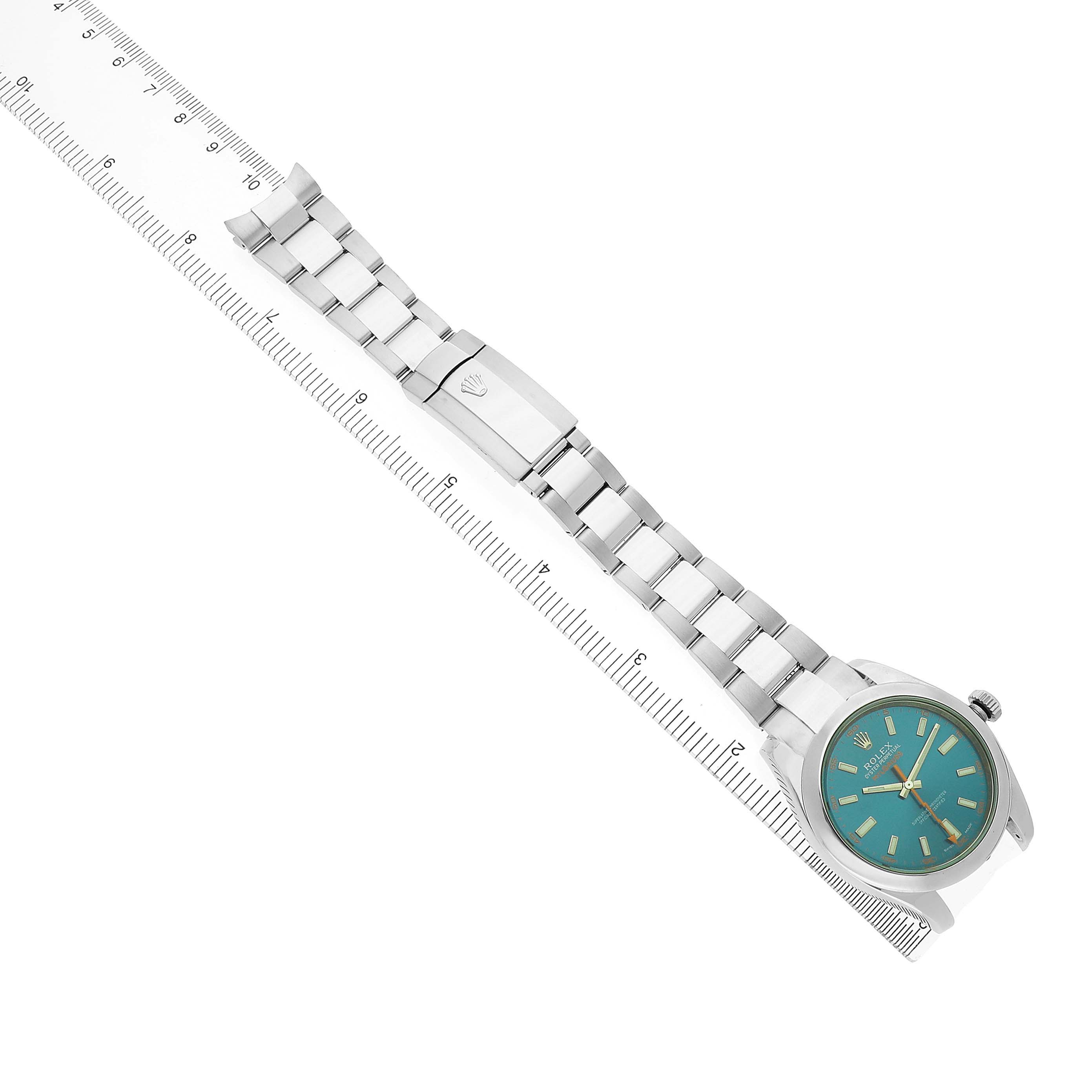 The Rolex Milgauss 116400 Men's Stainless Steel Blue Dial is shown from a top-down angle, displaying the bracelet and face next to a ruler.