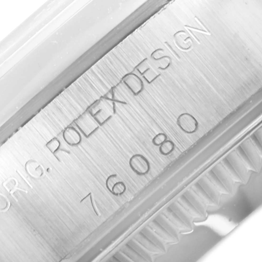 The image shows a close-up of the side of a Rolex Oyster Perpetual 76080 Women's Stainless Steel Black Dial 76080 Women's Stainless Steel Black Dial watch, focusing on the engraved model number "76080" and the text "ORIG. ROLEX DESIGN."