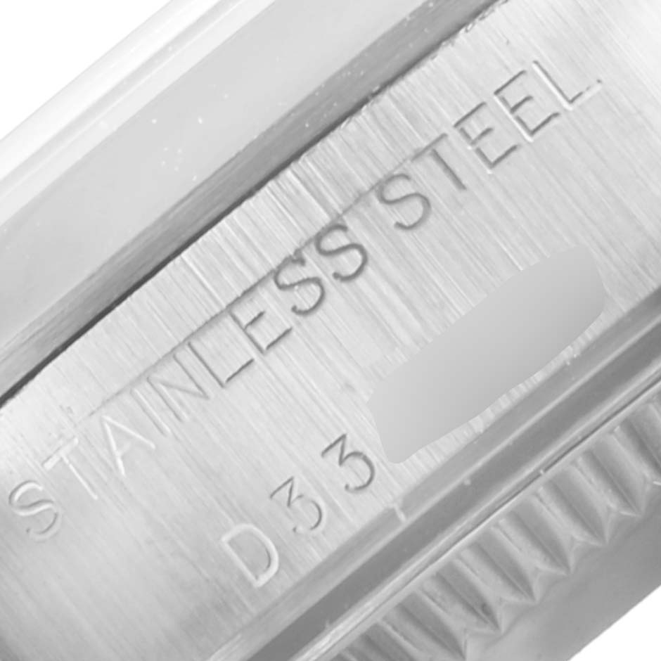 The image shows an extreme close-up of the stainless steel engraved on the bezel of a Rolex Oyster Perpetual 76080 Women's Stainless Steel Black Dial 76080 Women's Stainless Steel Black Dial watch.