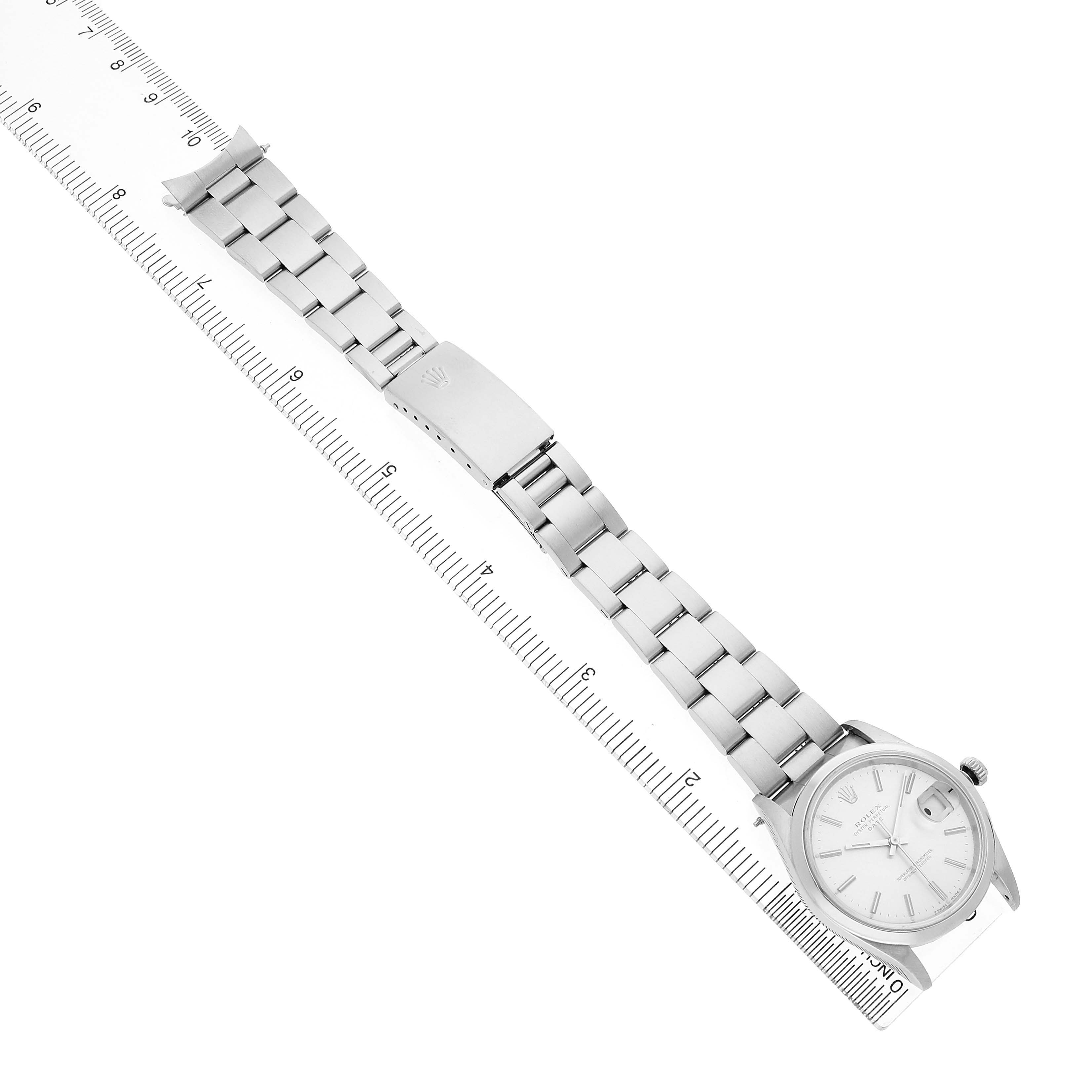 The image shows a Rolex Date 15200 Men's Stainless Steel Silver Dial watch lying flat, highlighting the bracelet, clasp, and watch face from a top-down angle.