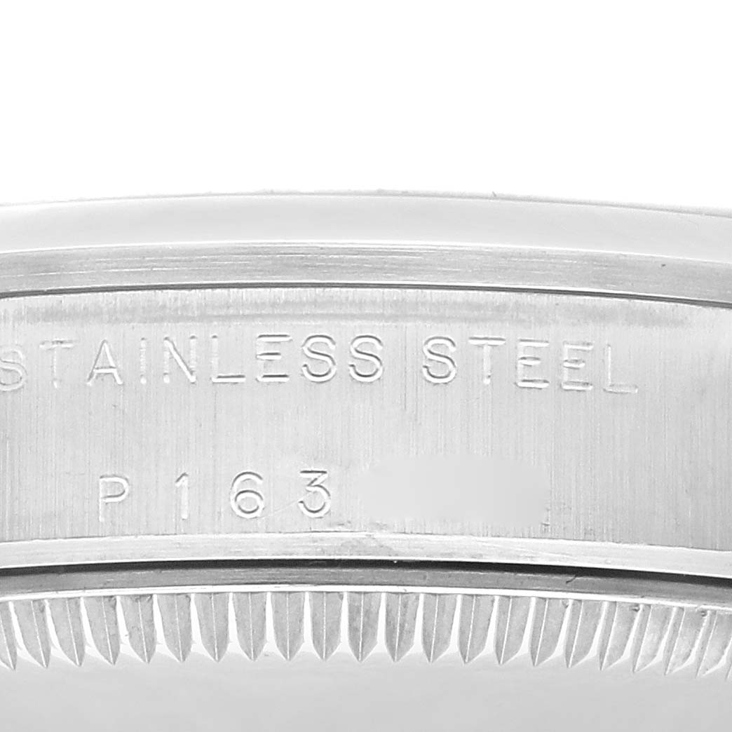 The image shows a close-up of the outer rim of the case back for a Rolex Mid-Size 77080 Women's Stainless Steel Black Dial 77080 Women's Stainless Steel Black Dial model, highlighting engraved text and material.