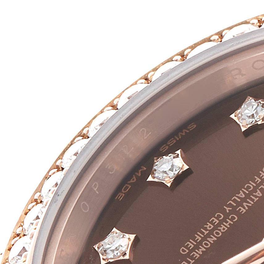 The image shows a close-up of the Rolex President 279135RBR Women's Rose Gold Brown Dial 279135RBR Women's Rose Gold Brown Dial model's bezel and part of the dial, highlighting the diamonds and markings.