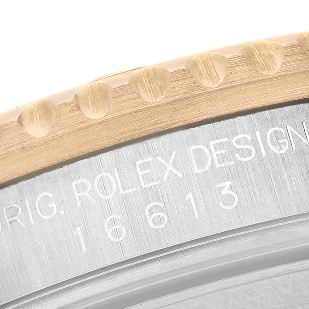 This image shows a close-up of the model number and design details on the bezel and case back of a Rolex Submariner 16613 Men's Steel and Gold (two tone) Champagne Dial 16613 Men's Steel and Gold (two tone) Champagne Dial.