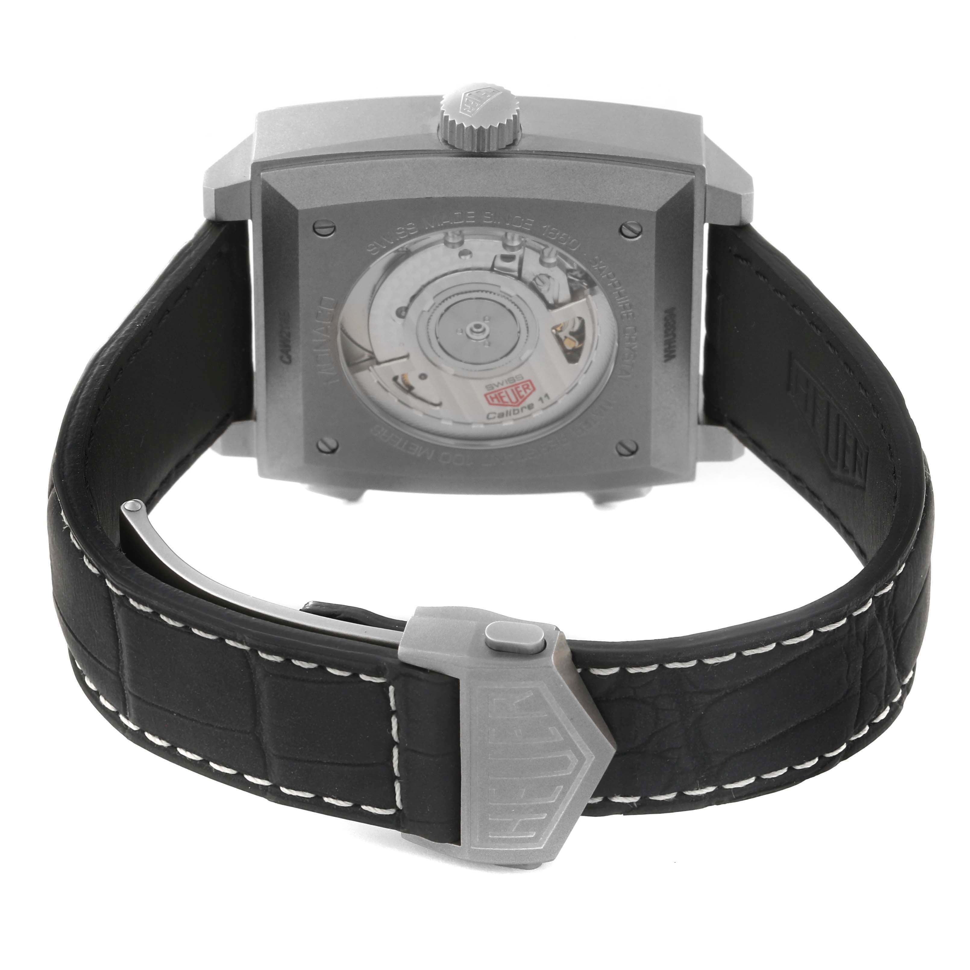 The Tag Heuer Monaco CAW218B.FC6496 Men's Titanium Silver Dial watch is shown from the back, highlighting the case back, movement, and clasp on the strap.