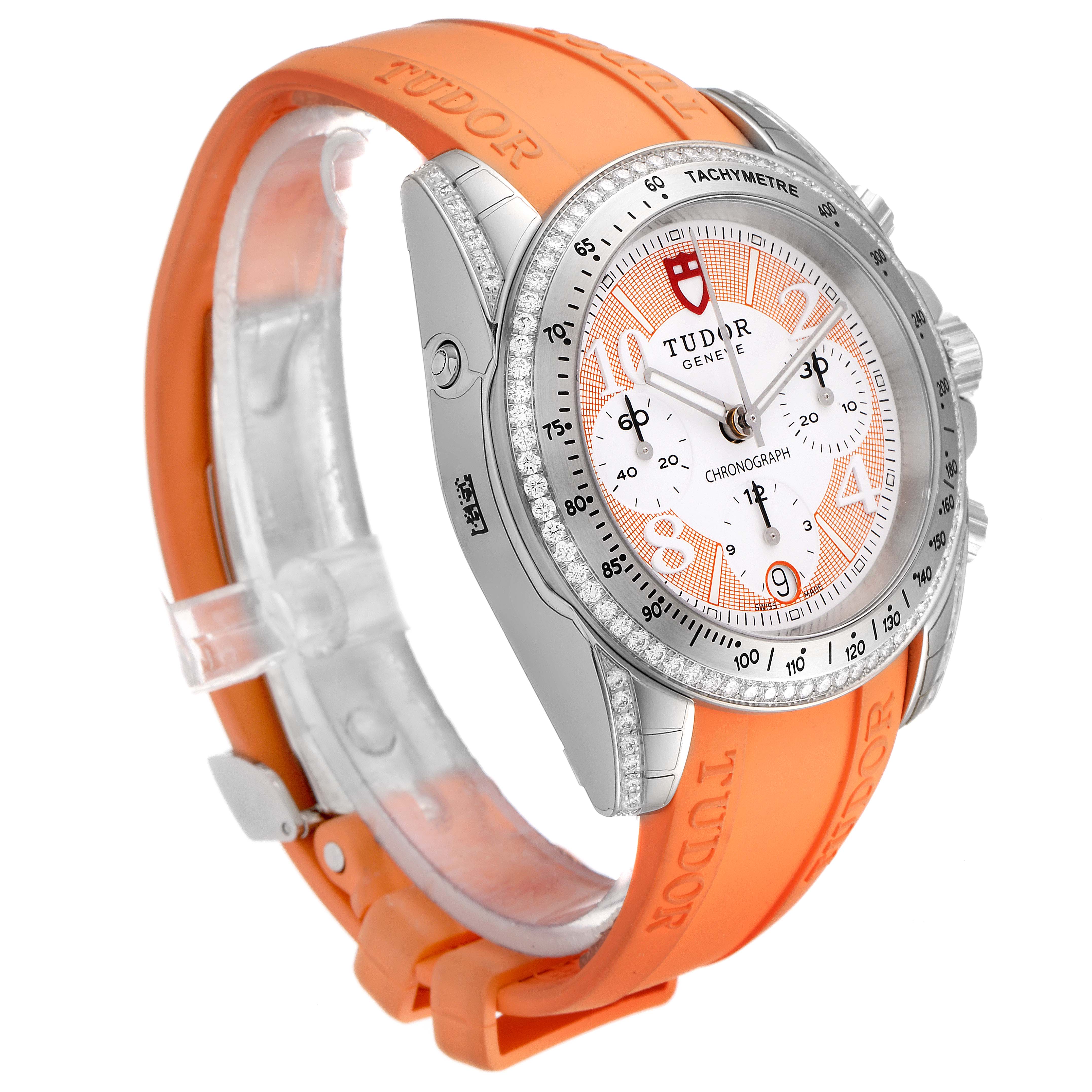 The Tudor Grantour 20310 Men's Stainless Steel White Dial 20310 Men's Stainless Steel White Dial watch is shown from a left side angle, highlighting its dial, bezel, and orange rubber strap.