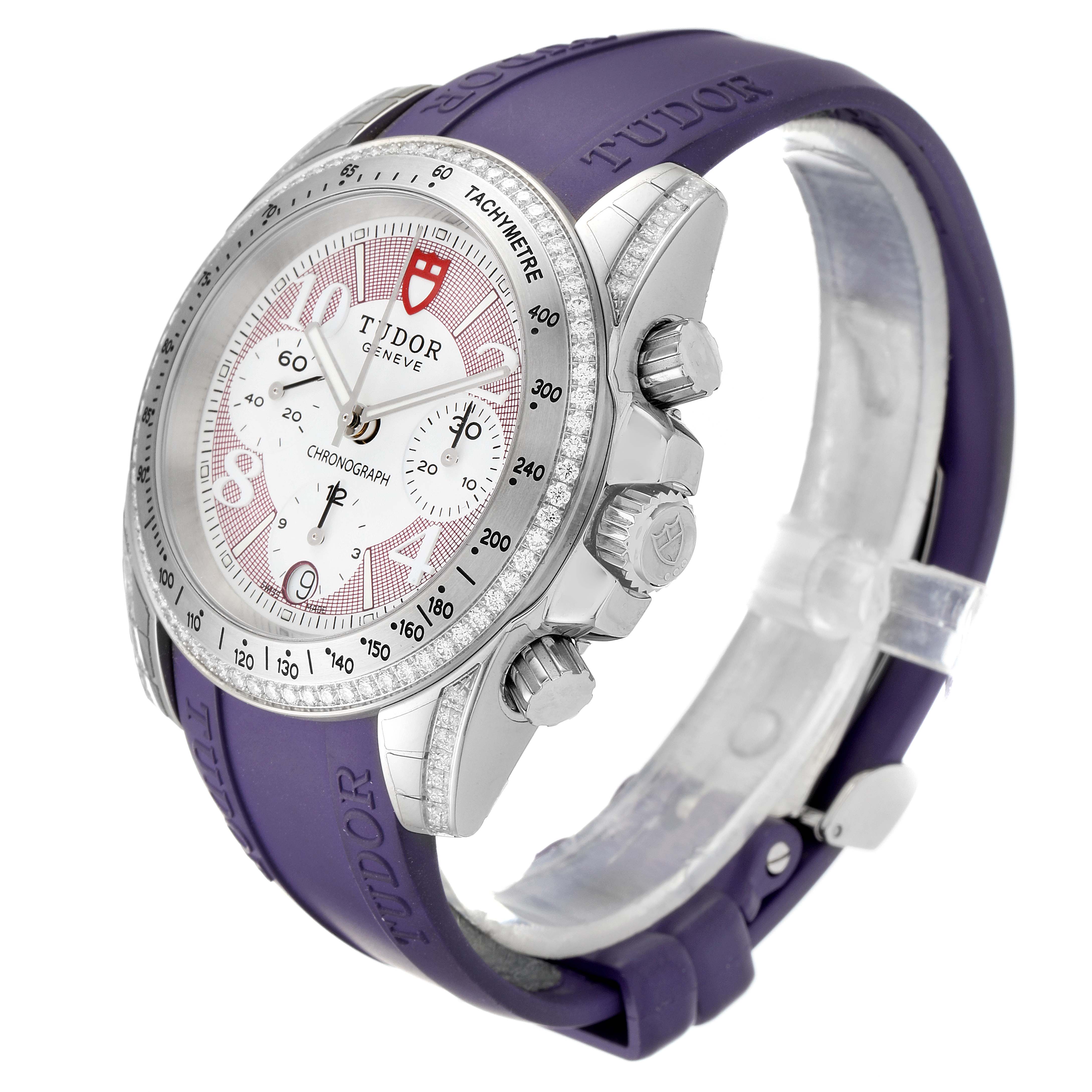 The Tudor Grantour 20310 Men's Stainless Steel White Dial 20310 Men's Stainless Steel White Dial model watch is shown at an angle highlighting the face, bezel, pushers, crown, and purple strap.