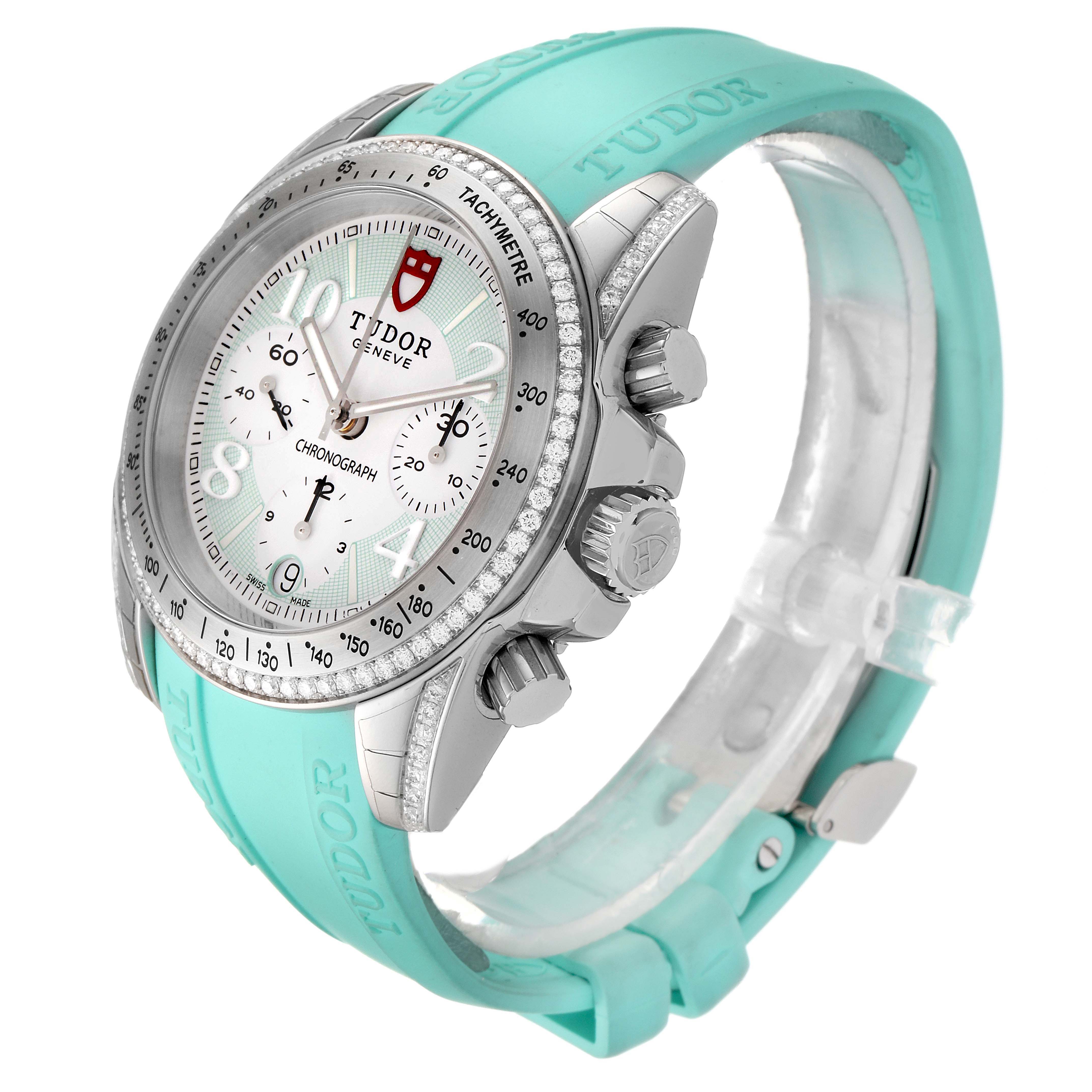 The image shows a Tudor Grantour 20310 Men
s Stainless Steel White Dial 20310 Men
s Stainless Steel White Dial watch at a three-quarter angle, highlighting its face, dial, crown, push buttons, and turquoise strap.